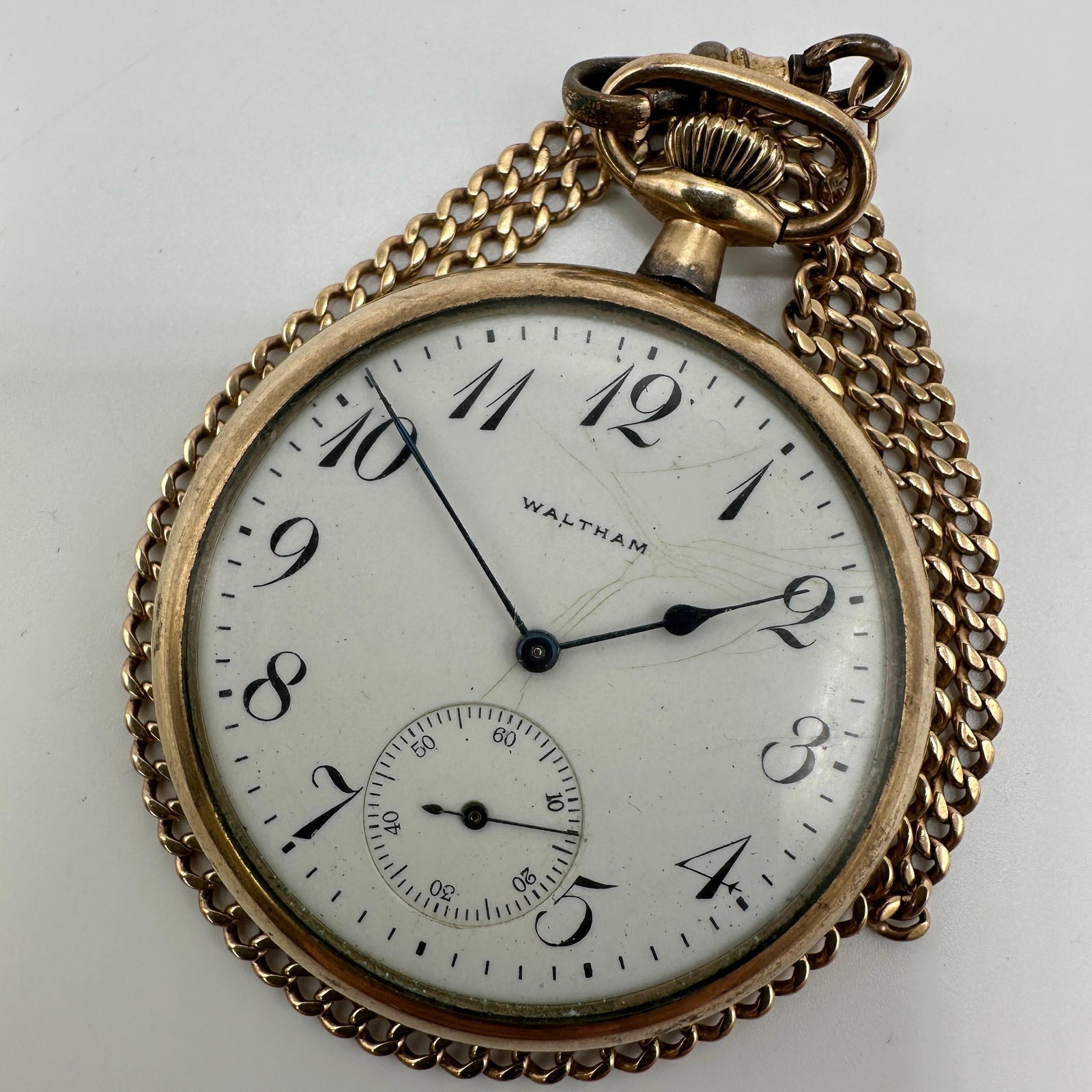 Antique Waltham Pocket Watch With Gold Filled Case and Chain: Antique Waltham pocket watch with white enamel dial, subsidiary seconds dial, and attached gold-tone curb link chain. Movement marked Waltham, Mass, Adjusted 17 Jewels with serial number 22193273. Int