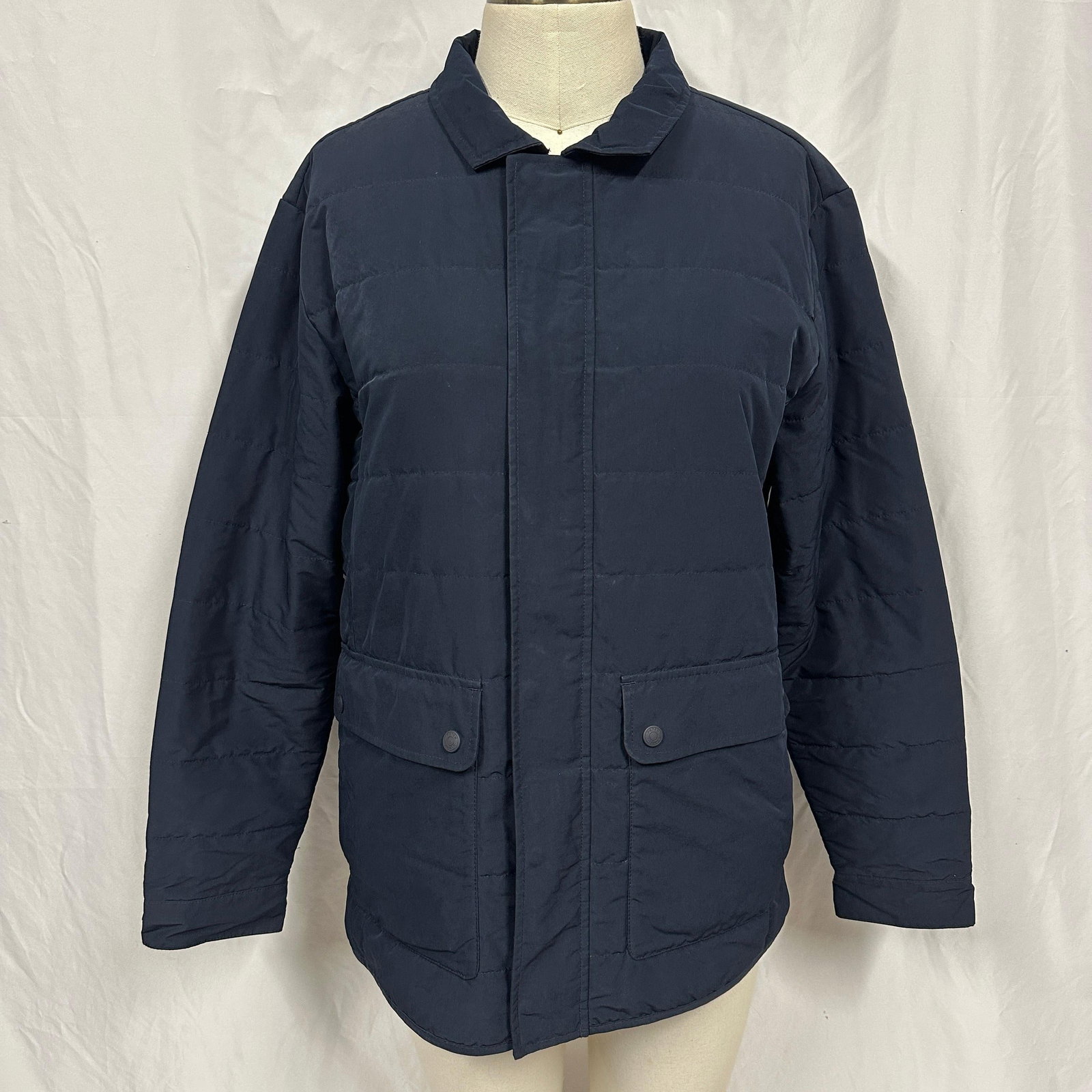 Peter Millar Mercer Quilted Style Navy Jacket Size Medium: Peter Millar Mercer quilted navy jacket marked size Medium. Features full zip and snap front closure, a spread collar, flap front pockets, interior zip pockets, and lightly quilted insulated construct