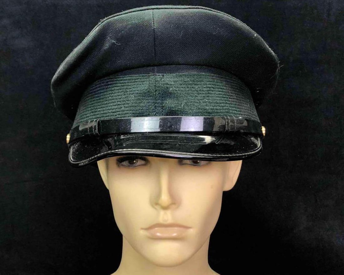 William Scully LTD Mens Rifle Green Service Cap: This lot contains a William Scully LTD men's rifle green service cap. The cap is a size 7-1/4 and weighs about 0.5lbs. The hat is in good used condition with some minor ware from use over time. There 