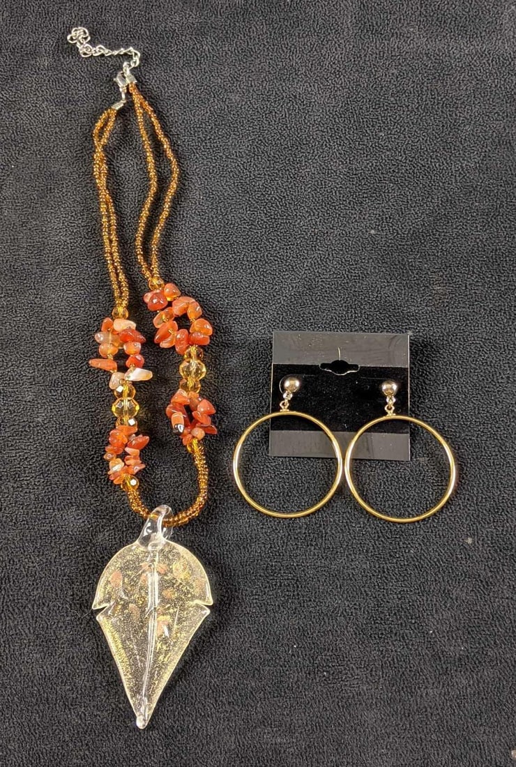 Necklace and Earrings Orange and Gold Color: Necklace and Earrings Orange and Gold Color This is a set of a necklace with orange beads and a glass leaf pendant with gold-colored hoop stud earrings. This set is in good condition with no known dam