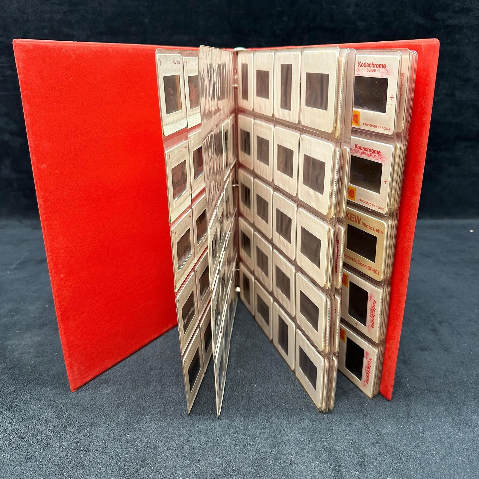 Collection Of Kodak Kodachrome and Ektachrome 35mm Slides Set 194: Large collection of 194 vintage 35mm color photographic slides housed in a red binder with plastic storage pages. Includes KEW Photo Labs, Kodak Kodachrome, and Ektachrome slides depicting family