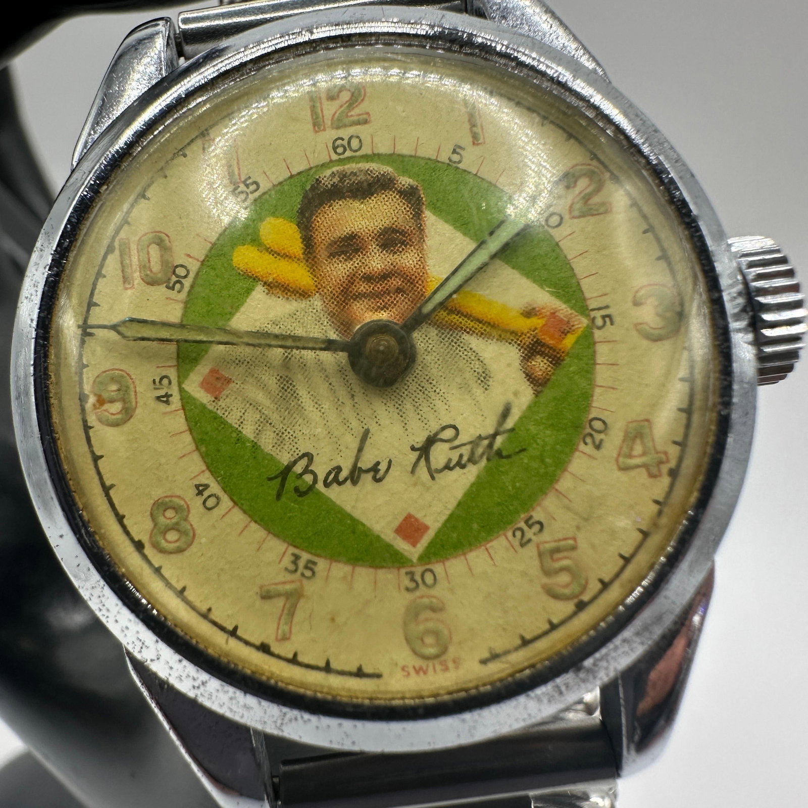 Babe Ruth Baseball Themed Swiss Wristwatch Vintage: Vintage Swiss-made wristwatch featuring a Babe Ruth baseball portrait dial with facsimile signature and baseball diamond motif. Watch retains an expandable metal band and is marked “Swiss”