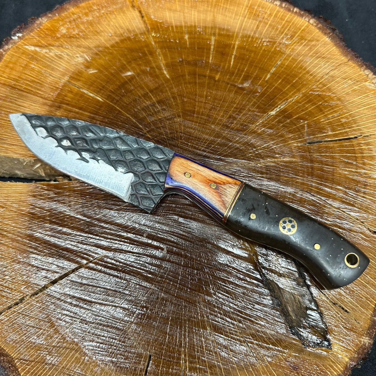 MHS Cutlery Textured Blade Knife with Leather Sheath P92: Fixed blade knife by MHS Cutlery featuring a textured steel blade and decorative spine work. The handle has a contoured, multi-colored wood/epoxy resin-style grip with metal mosaic pin accents.