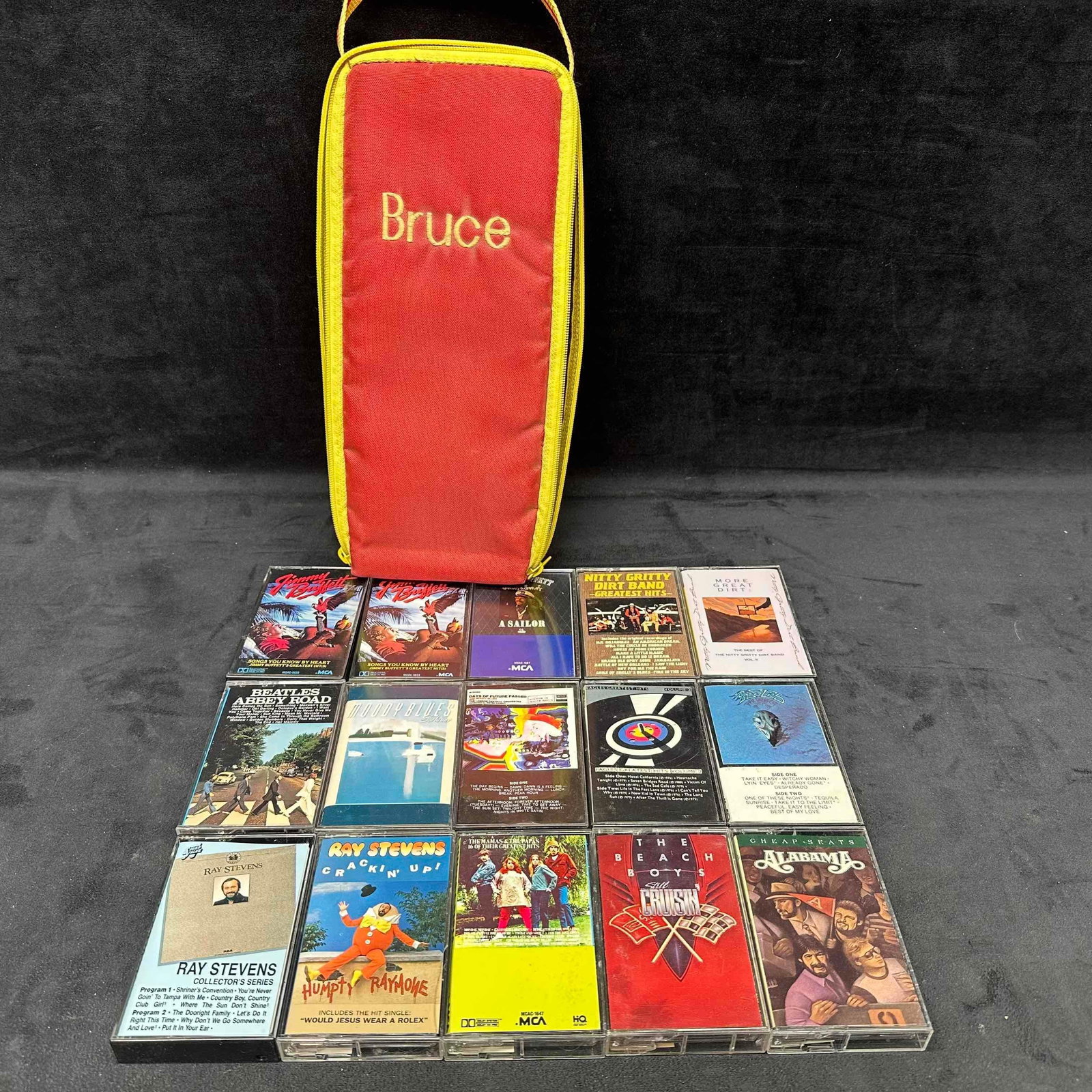 Lot of 15 Vintage Cassette Tapes with Case Classic Rock and Country Collection: Collection of fifteen vintage cassette tapes featuring classic rock, pop, and country artists. Includes original plastic cases, stored in a personalized red/yellow zippered cassette case marked Bruce.