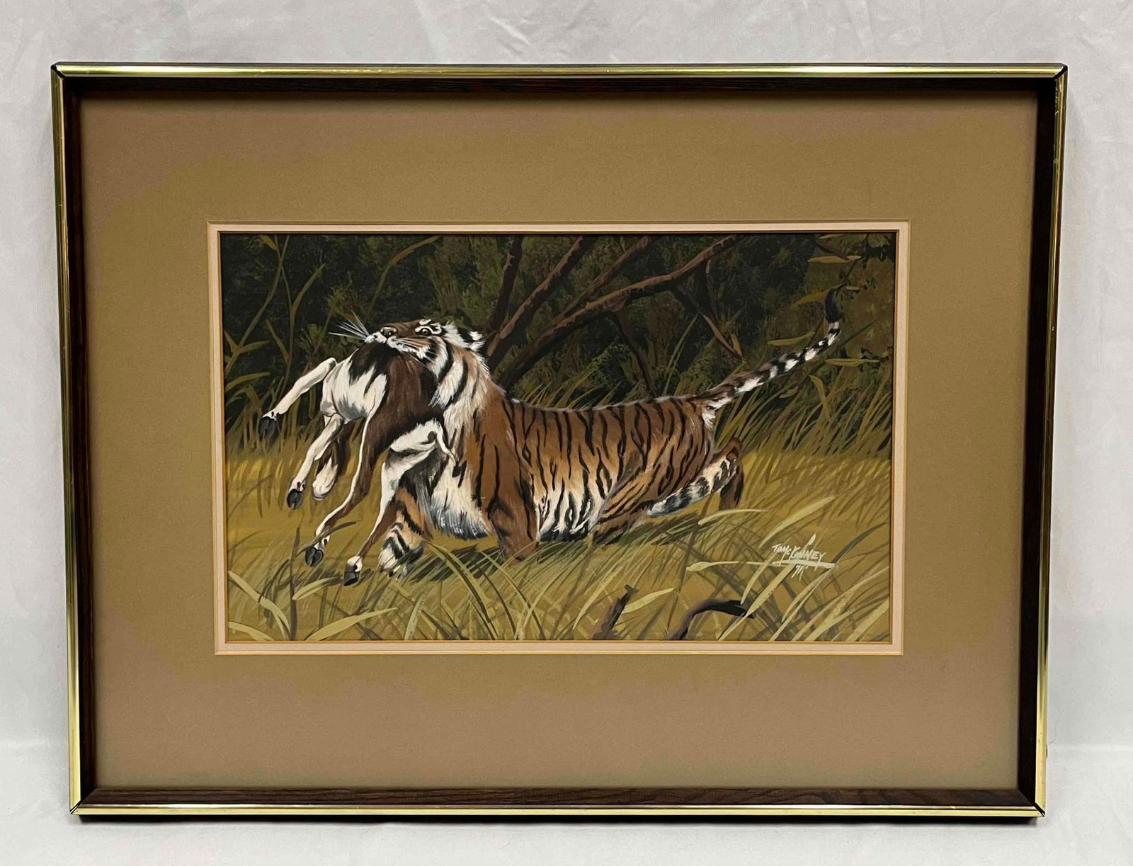 Framed Print Of A Tiger With Its Prey By Tom C Kenney '71: This lot contains a Framed Print Of A Tiger With Its Prey By Tom C Kenny '71. It is approx 19" x 25 1/4". Total weight is approx 6.5lbs. Overall the print is in good used condition as it is