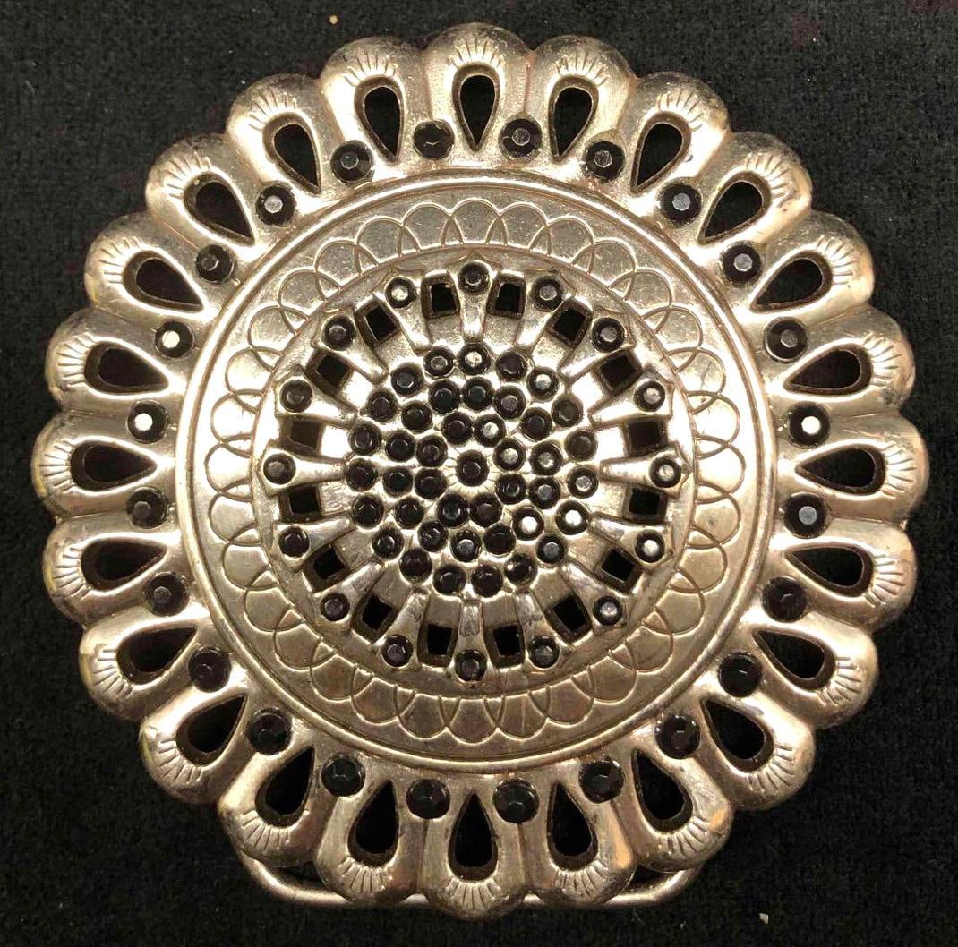 Metal Medallion Flower Novelty Belt Buckle Enmon Copyright: This lot contains a metal medallion flower novelty belt buckle Enmon copyright. It is approx 3 1/2" x 3 1/2" and weighs about 0.2lbs. The belt buckle is in good used condition with some minor ware fro