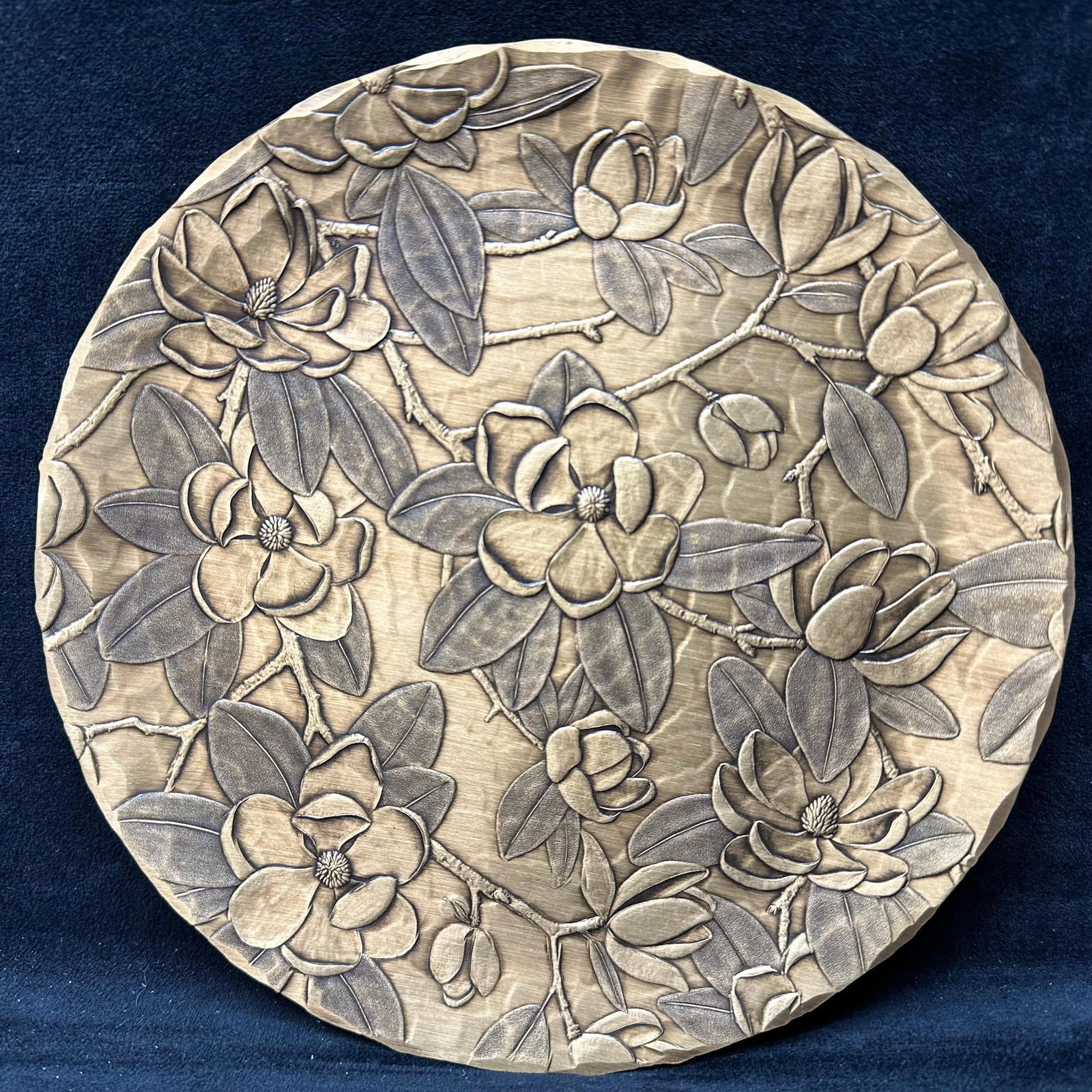Wendell August Solid Bronze Floral Wall Plaque Plate 75th Anniversary Edition: Handmade solid bronze wall plaque by Wendell August, featuring an embossed floral and branch motif in a round form. Stamped on the reverse with Wendell August Forge marks, Solid Bronze, and the 75th