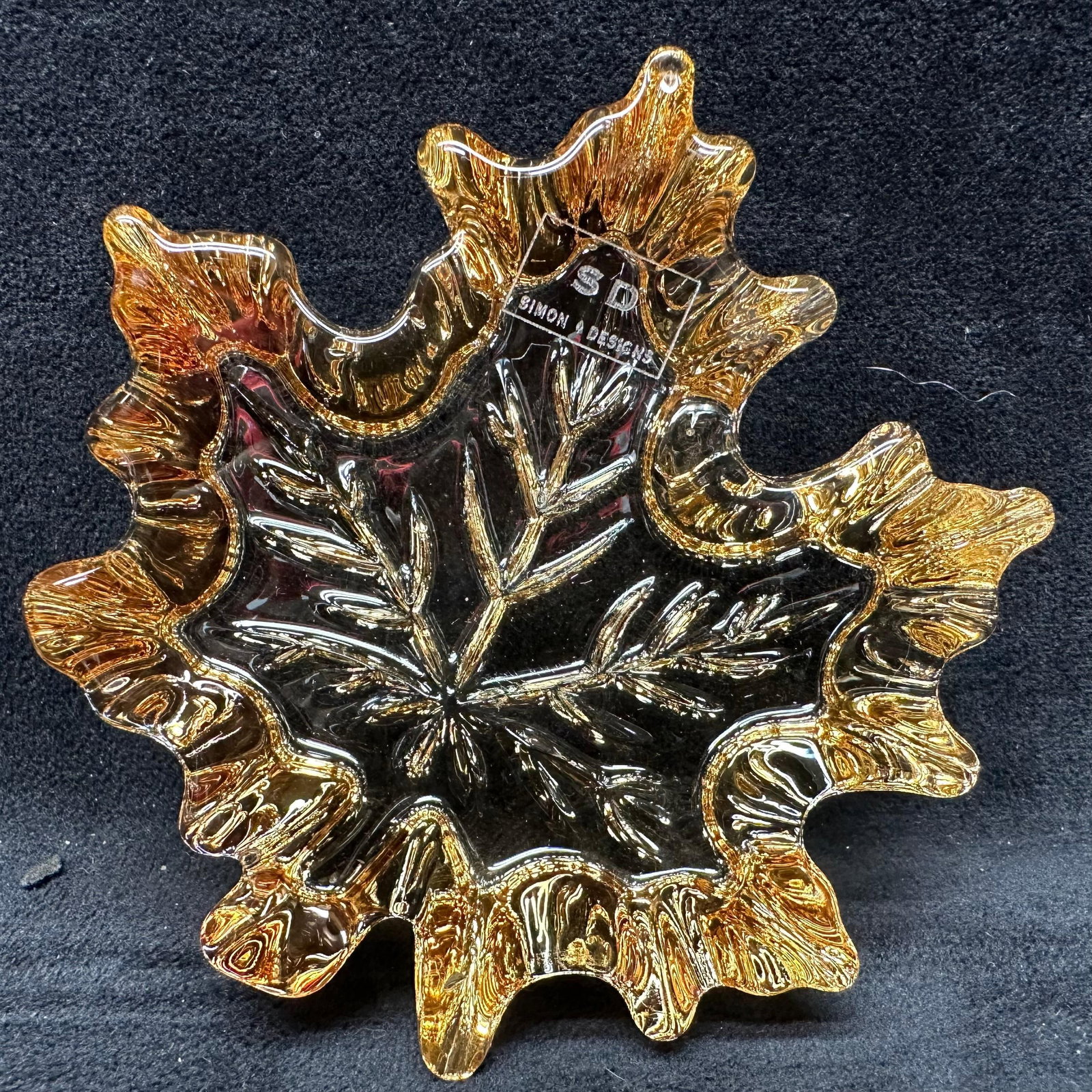 Amber Shimmer Crystal Leaf Paperweight in Box Glass Art: Decorative amber-tinted solid crystal paperweight in the form of a ruffled maple leaf with detailed veining. Heavy, clear amber glass with good light refraction. Marked SD Simon Designs. Includes
