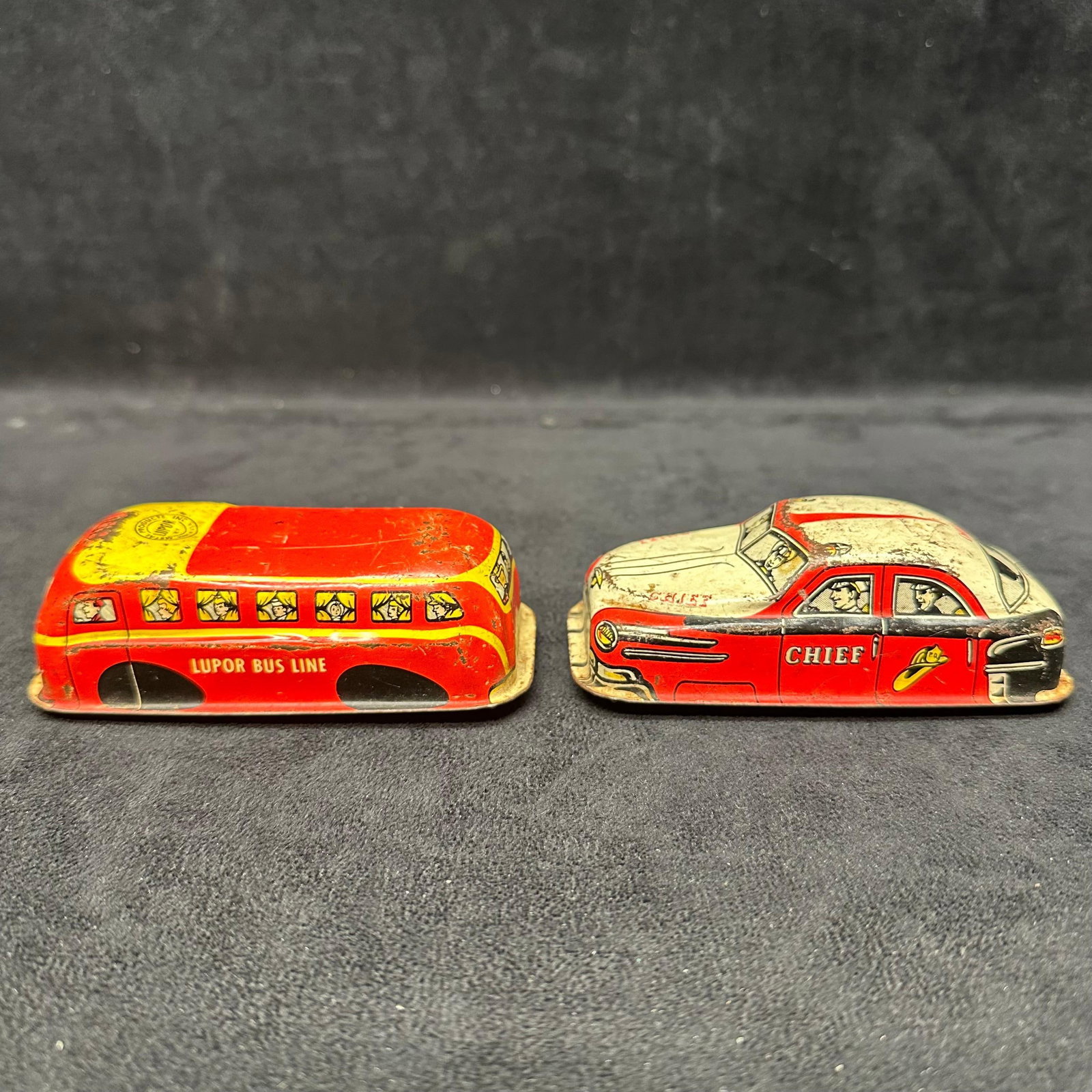Pair of Vintage Lupor Tin Litho Toys Lupor Bus Line and Chief Car NY Metal Products: Two early mid-20th-century tin lithographed toy vehicles by Metal Products Mfg., New York, each marked Lupor. Includes a red/yellow Lupor Bus Line bus and a red/white Chief patrol-style car.