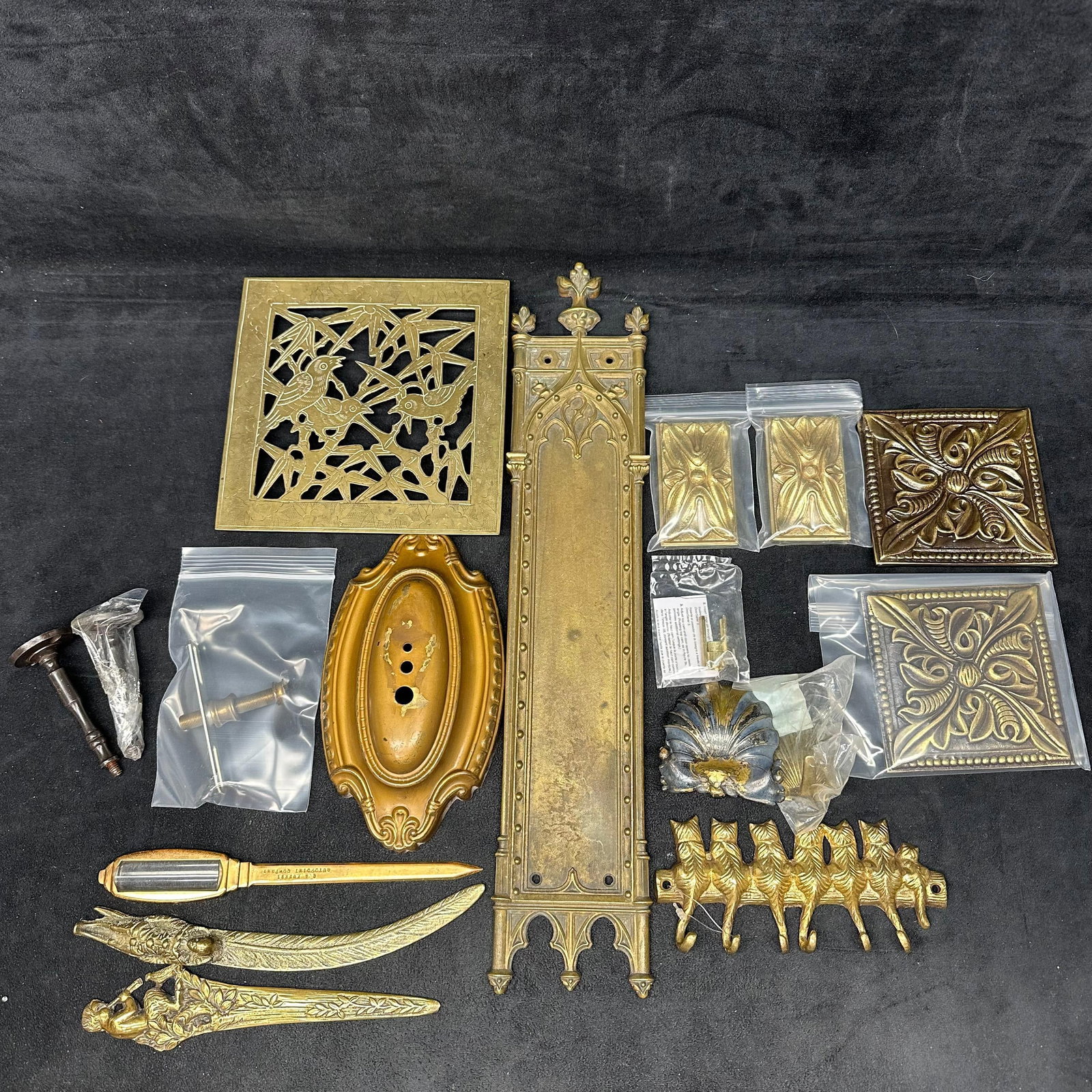 Large Mixed Lot of Vintage and Modern Brass Hardware and Decorative Metal Pieces: An assorted lot of brass and metal hardware, including decorative plates, ornate panels, wall hooks, escutcheons, finials, letter openers, and various architectural-style trim pieces. A mix of vintage