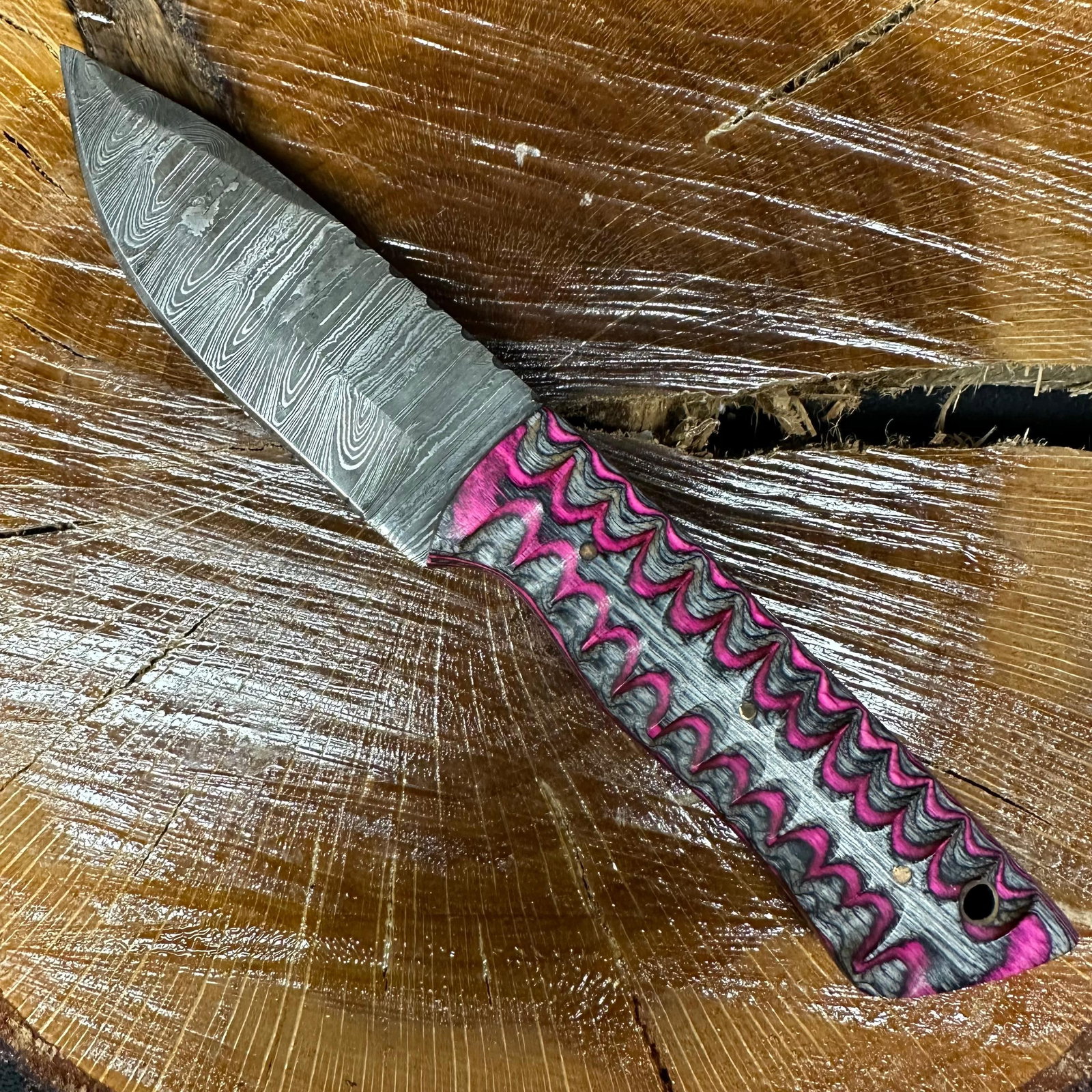 MHS Cutlery Fixed Blade Knife Pink Gray Design Handle P44: Fixed blade knife by MHS Cutlery featuring a textured steel blade with a plain cutting edge and decorative spine work. The handle has a contoured, pink and gray resin-style grip with metal mosaic pin