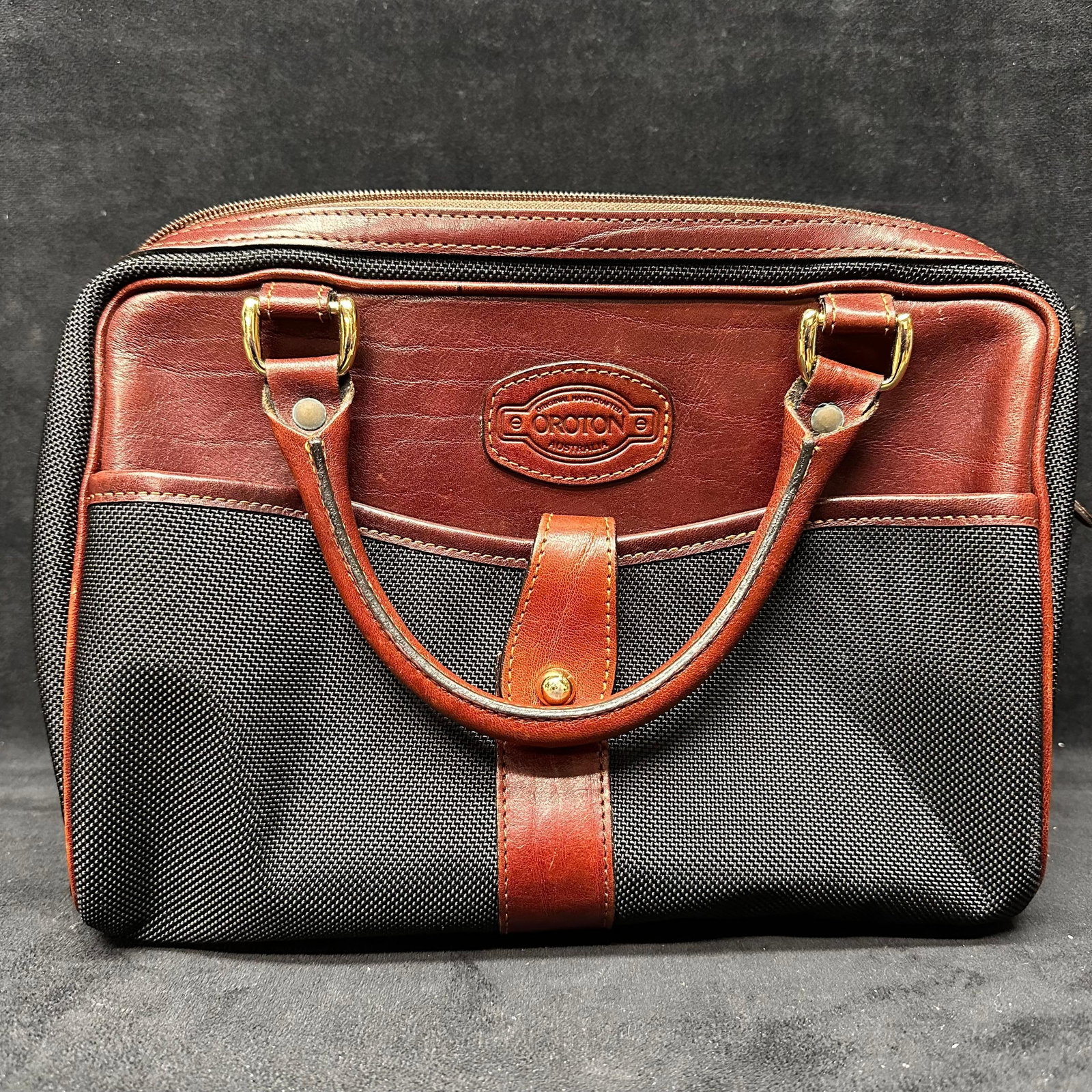 Oroton Leather and Canvas Satchel Handbag with Detachable Strap: Oroton satchel-style handbag featuring a black woven canvas body with brown leather trim and handles. Marked Oroton at the front. Zip-top closure with fabric-lined interior. Includes detachable