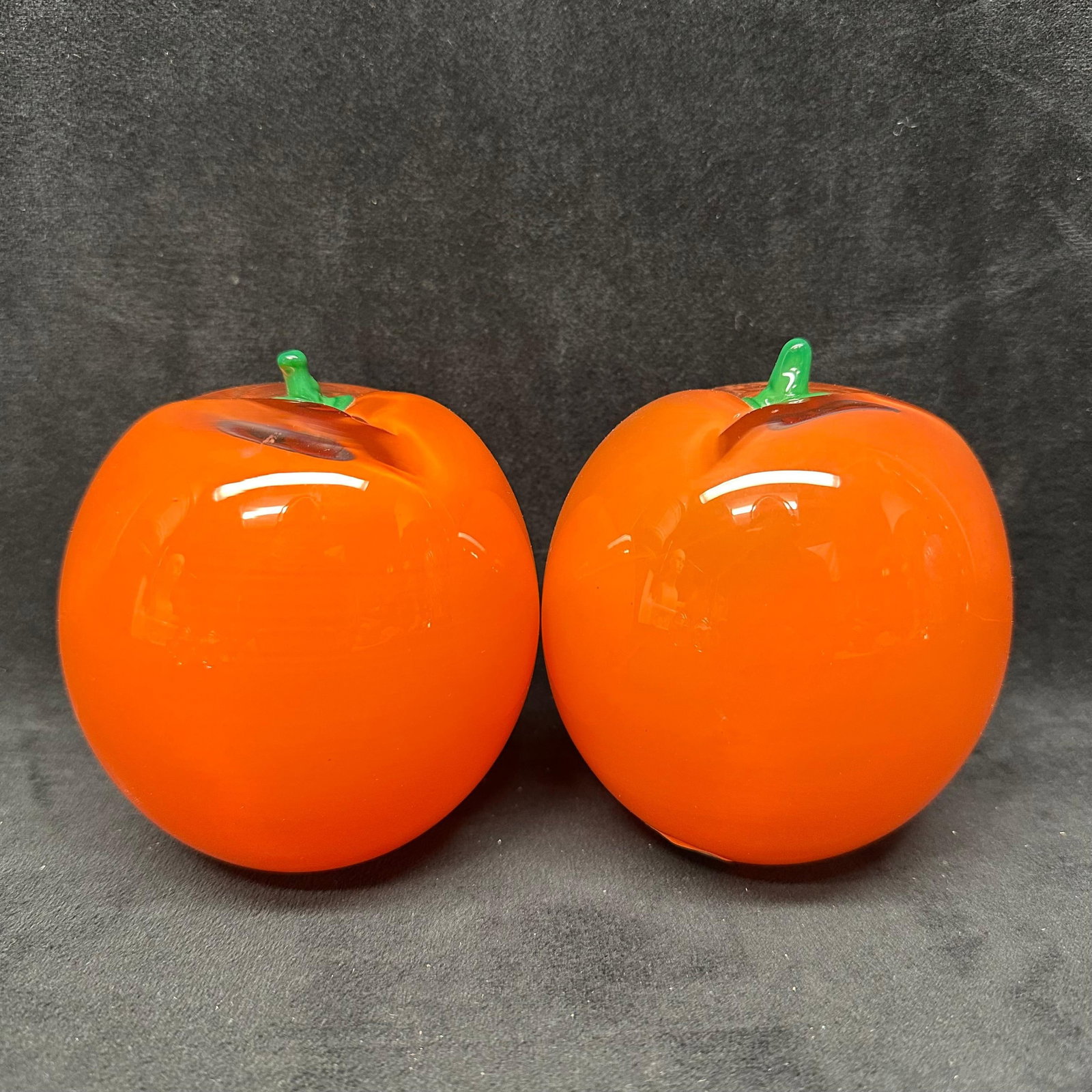Studio Ahus Swedish Art Glass Orange Sculptures Pair Orange Sweden Paperweight: Pair of Studio Ahus art glass orange sculptures produced in Sweden. Both examples are hand-blown in a vibrant orange glass with applied green glass stems. Each retains the original Studio Ahus Sw