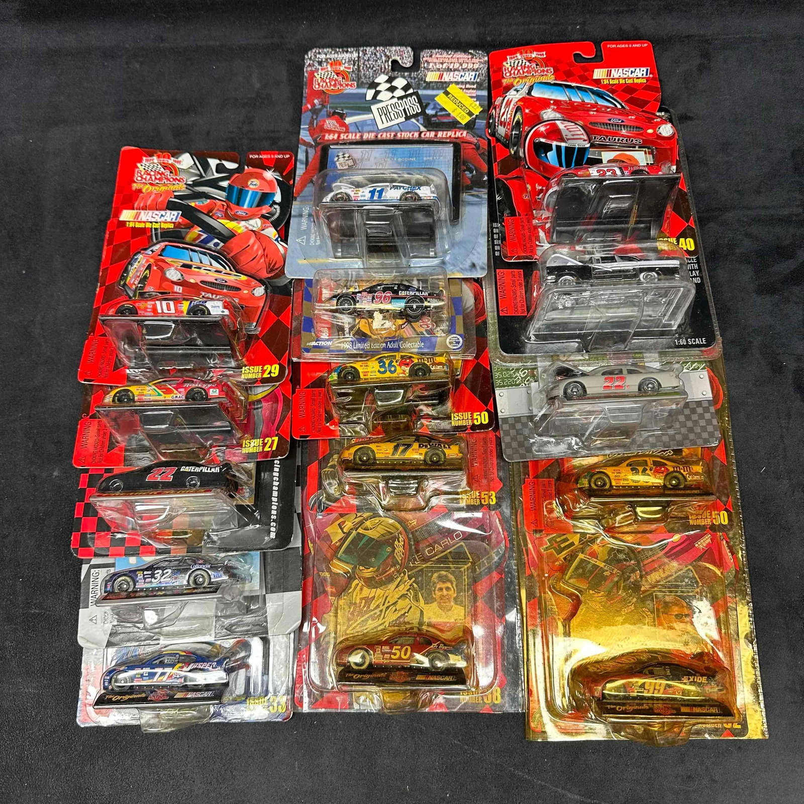 Lot of 15 NASCAR 1:64 Die-Cast Cars Racing Champions and Action Collectibles: Collection of 15 NASCAR die-cast cars, all in original packaging. Brands include Racing Champions and Action Collectibles, with various drivers and themes represented. Cars are 1:64 scale, with some m