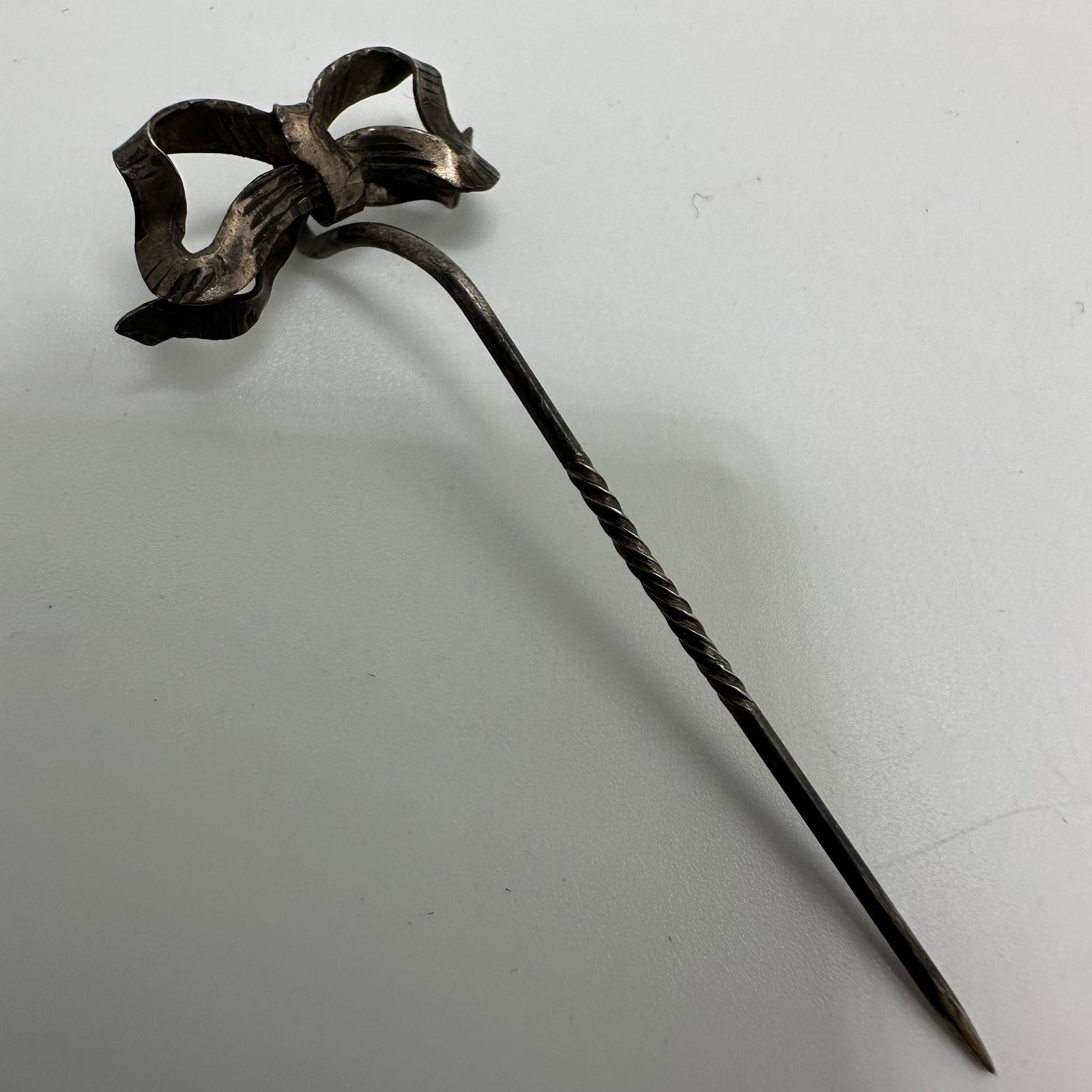 Silver Tie Ribbon Stick Hat Pin: This item is in good pre-owned, previously used/displayed condition with noticeable light wear and surface scratches. Please reference all photos for full details. This piece of jewelry has been teste