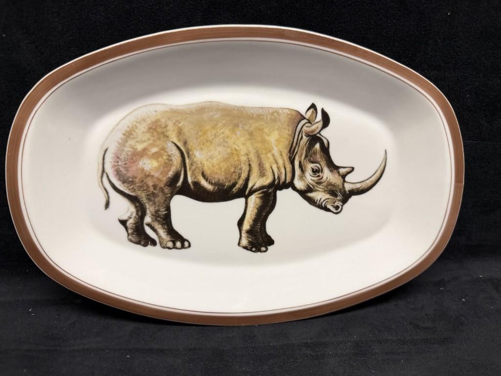 Mottahedeh Rhino Transferware Platter: Mottahedeh Vista Alegre Portugal porcelain oval serving dish featuring a detailed rhinoceros motif rendered in naturalistic tones, bordered by a brown band along the rim. The underside bears both Mott