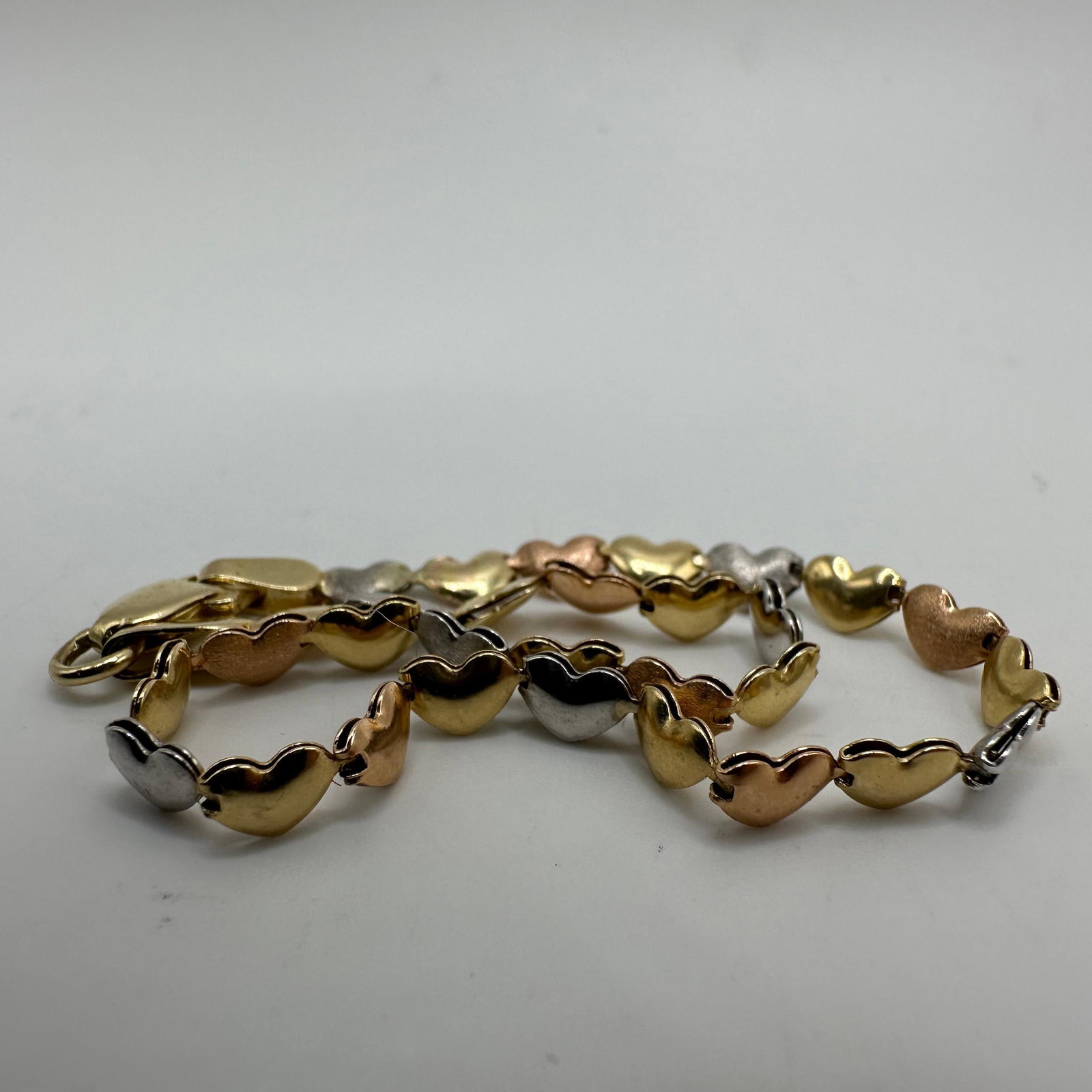 Tri-Tone Stampato Style Heart 14K Gold Bracelet: This item is in good pre-owned, previously used/displayed condition with noticeable light wear and surface scratches. Please reference all photos for full details. This piece of jewelry has been teste