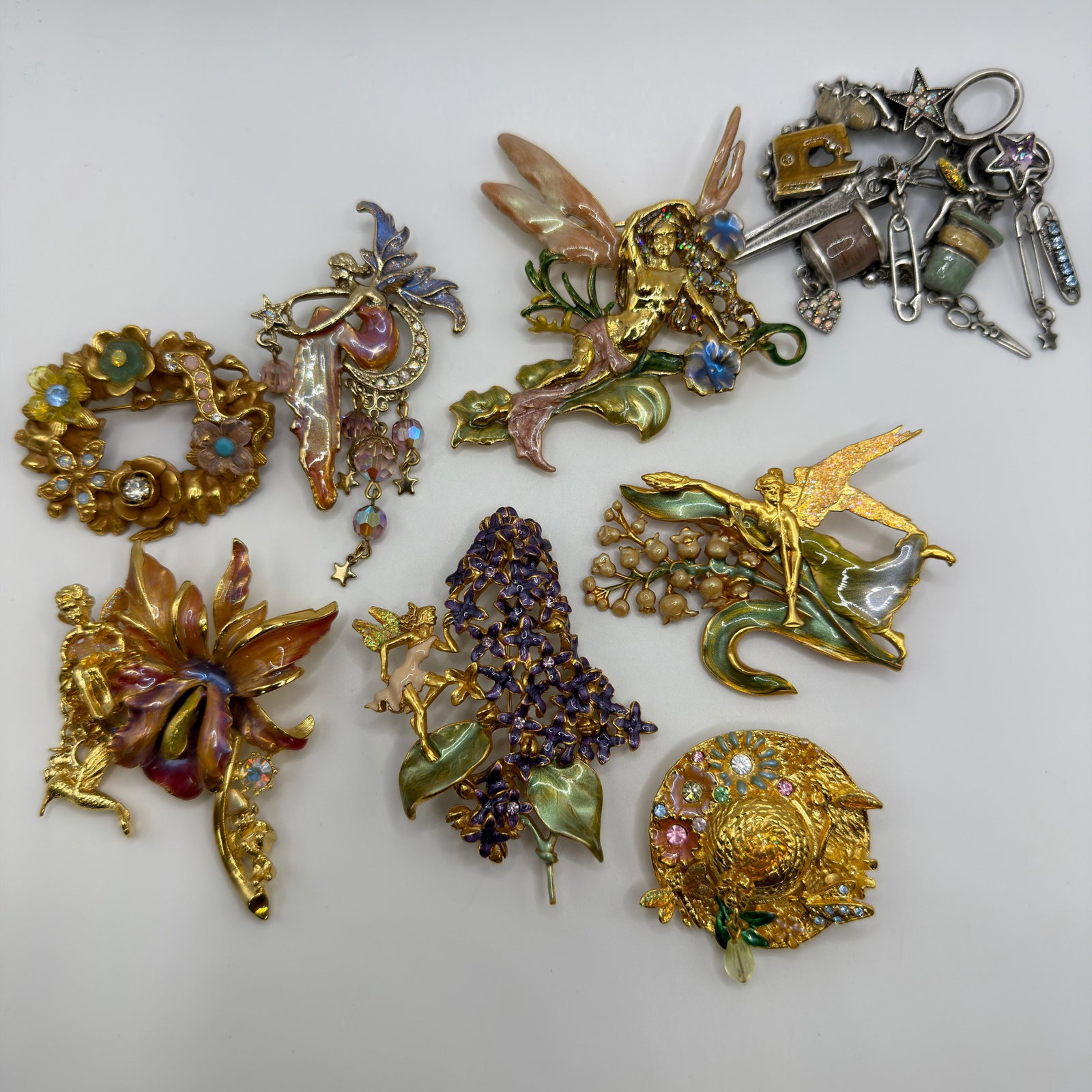 8 Kirks Folly Fantasy Fairy and Enamel Costume Jewelry Brooch Collection: Collection of eight Kirks Folly fantasy-themed costume brooches featuring fairies, floral motifs, whimsical sewing accessories, enchanted garden scenes, dragonfly, wisteria, fairy wings, and a decorat