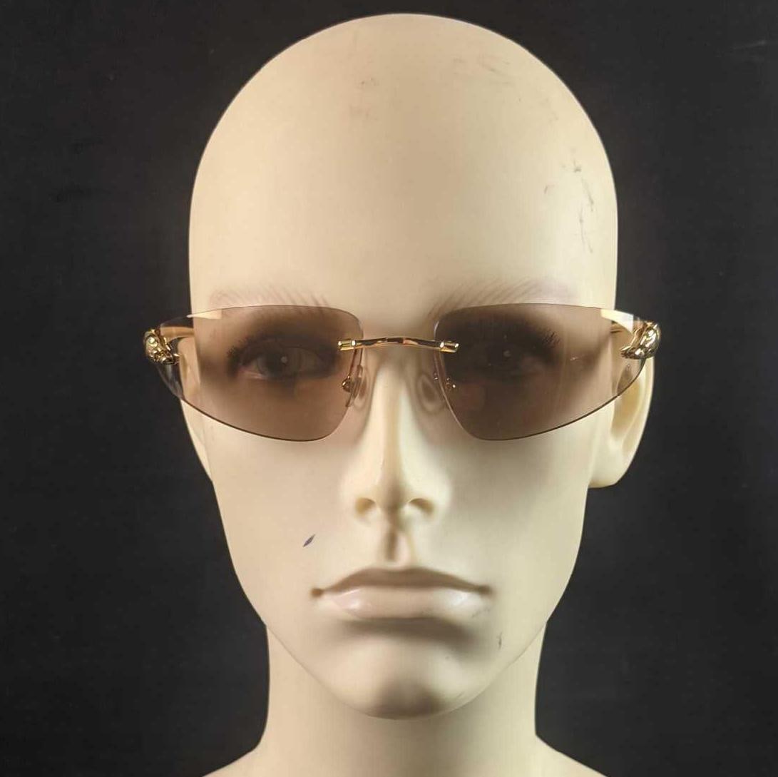 Cartier Brown 110 Panther Rimless Sunglasses: True to the brand, this pair of shades by Cartier exudes indulgence. Part of the Panthere De Cartier collection, these rimless sunglasses feature gold-tone arms with the iconic panther detailing on th
