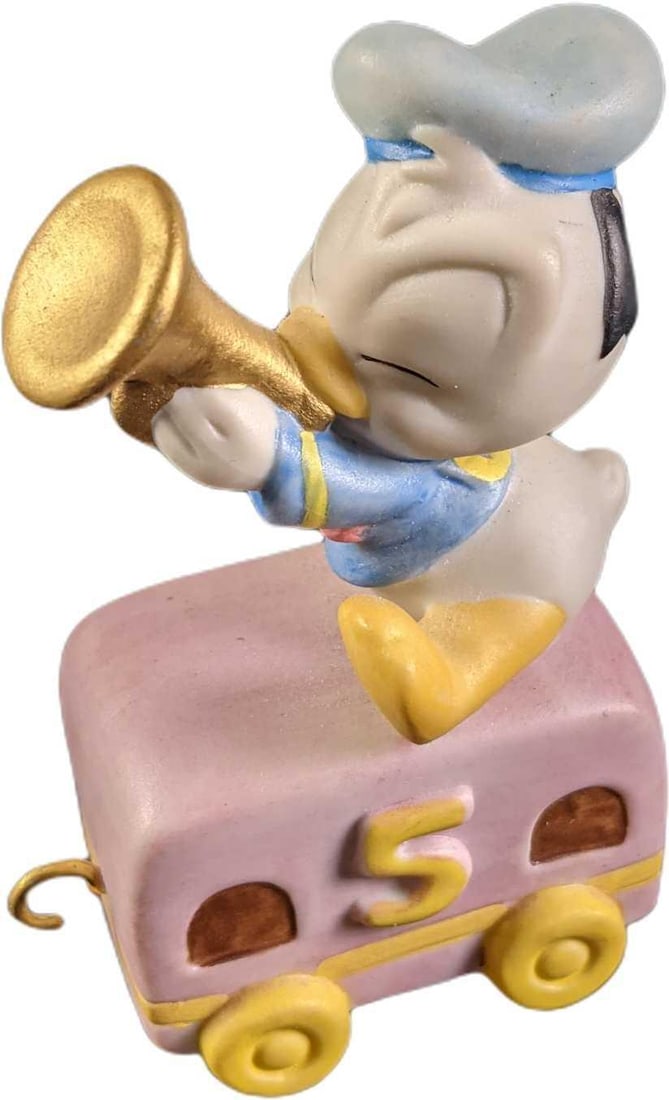 Disney Baby Donald Duck Porcelain Train: Disney Baby Donald Duck Porcelain Train. Baby Donald plays a horn on top of a train cabin. This is approx 2 1/2" x 1 1/4" x 3 1/2" and it weighs under one pound at 0.15lb. The train is in a good, used
