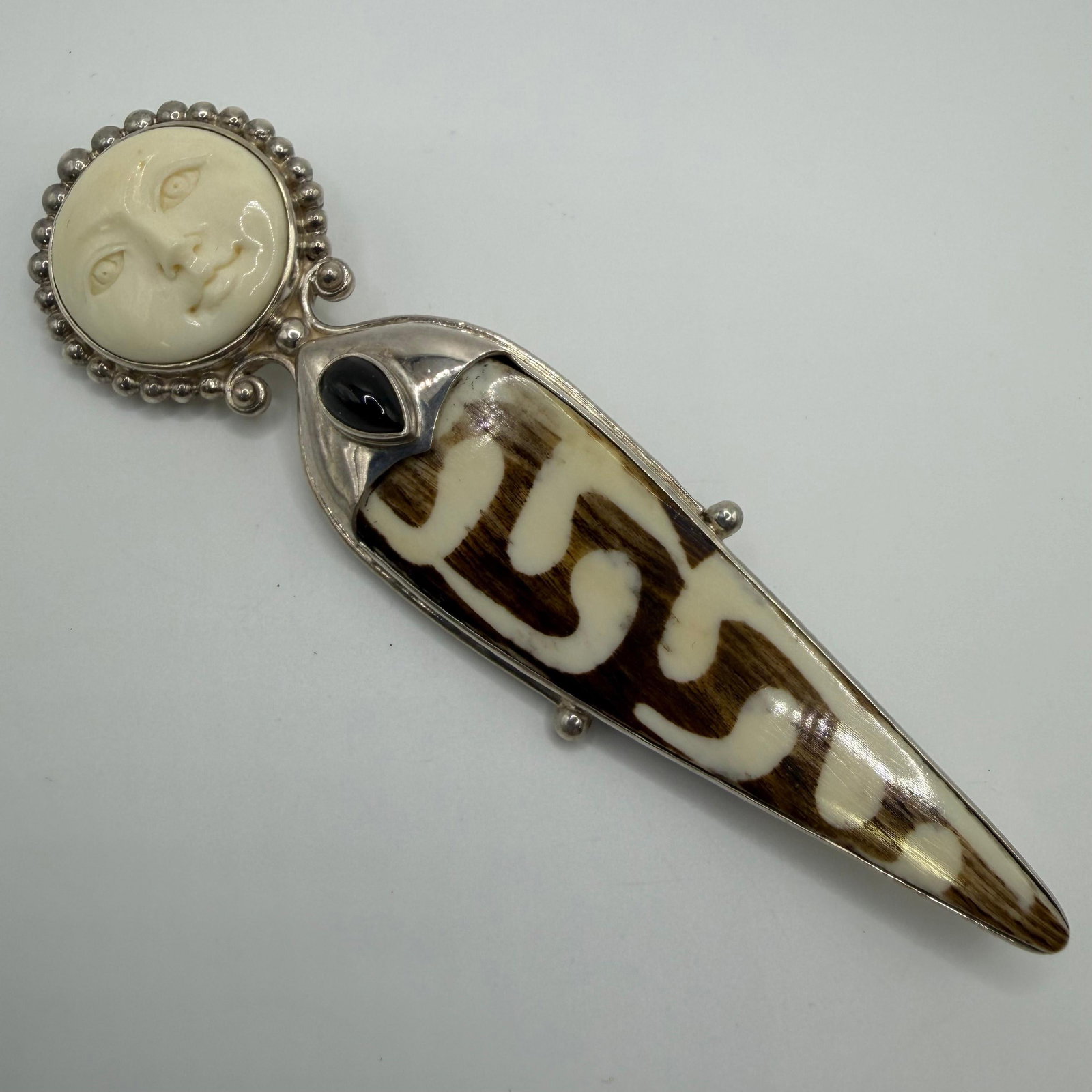 Carved Moon Face Sterling Silver Brooch Pendant with Onyx and Batik Bone: This item is in pre-owned, previously used/displayed condition with noticeable light wear and surface scratches. Please reference all photos for full details. This piece of jewelry has been tested and