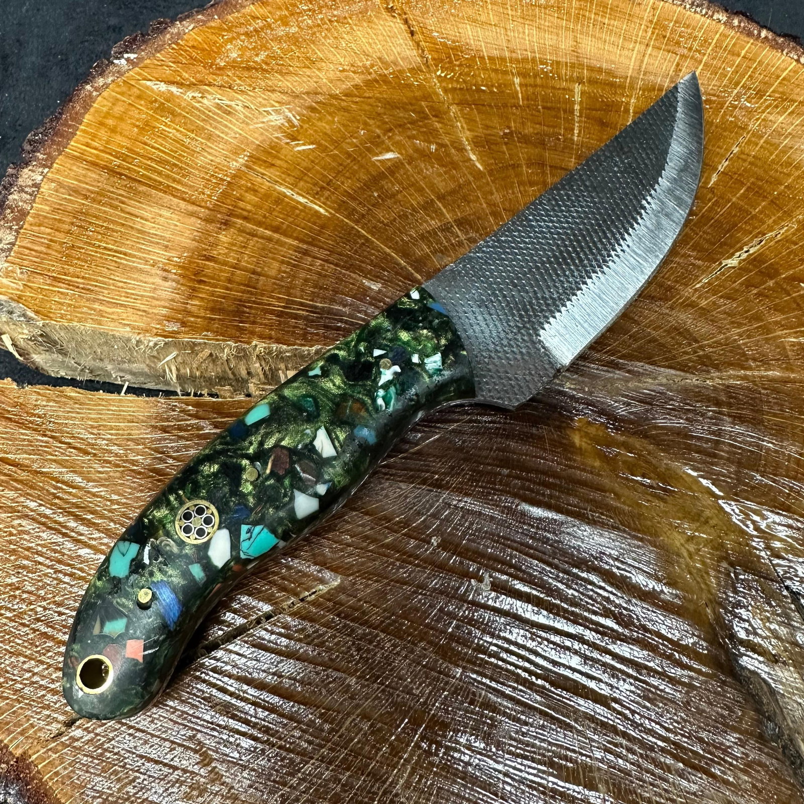MHS Cutlery Straight Steel Blade Knife Black Multi Colored Handle: Fixed straight back-style blade knife by MHS Cutlery featuring a textured steel blade and decorative spine work. The handle has a contoured, black multi-colored resin-style grip with metal mosaic pin 