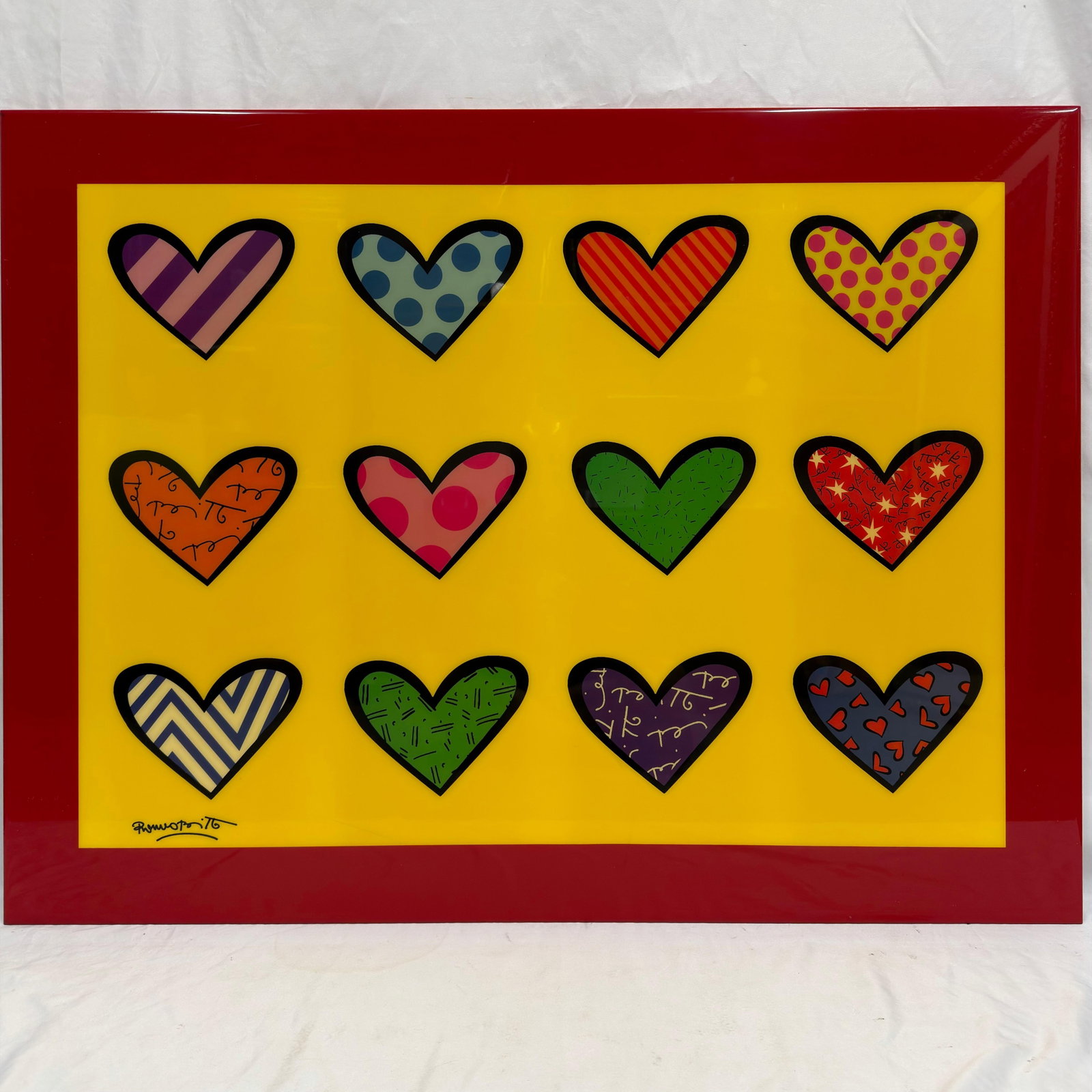 After Romero Britto Pop Art Hearts Wall Panel Print: Colorful pop art wall panel print depicting twelve patterned hearts against a bright yellow background with a glossy red border. Print signed "Britto" lower left. A vibrant decorative