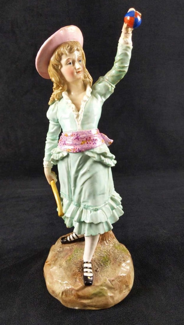 Vintage Ernst Bohne Porcelain Young Girl W Ball: Here is a hand-painted porcelain figurine of a young Victorian type girl in a blue dress with a pink and yellow hat. She also carries a stick and a colorful ball. She might be dressed fancy, but she