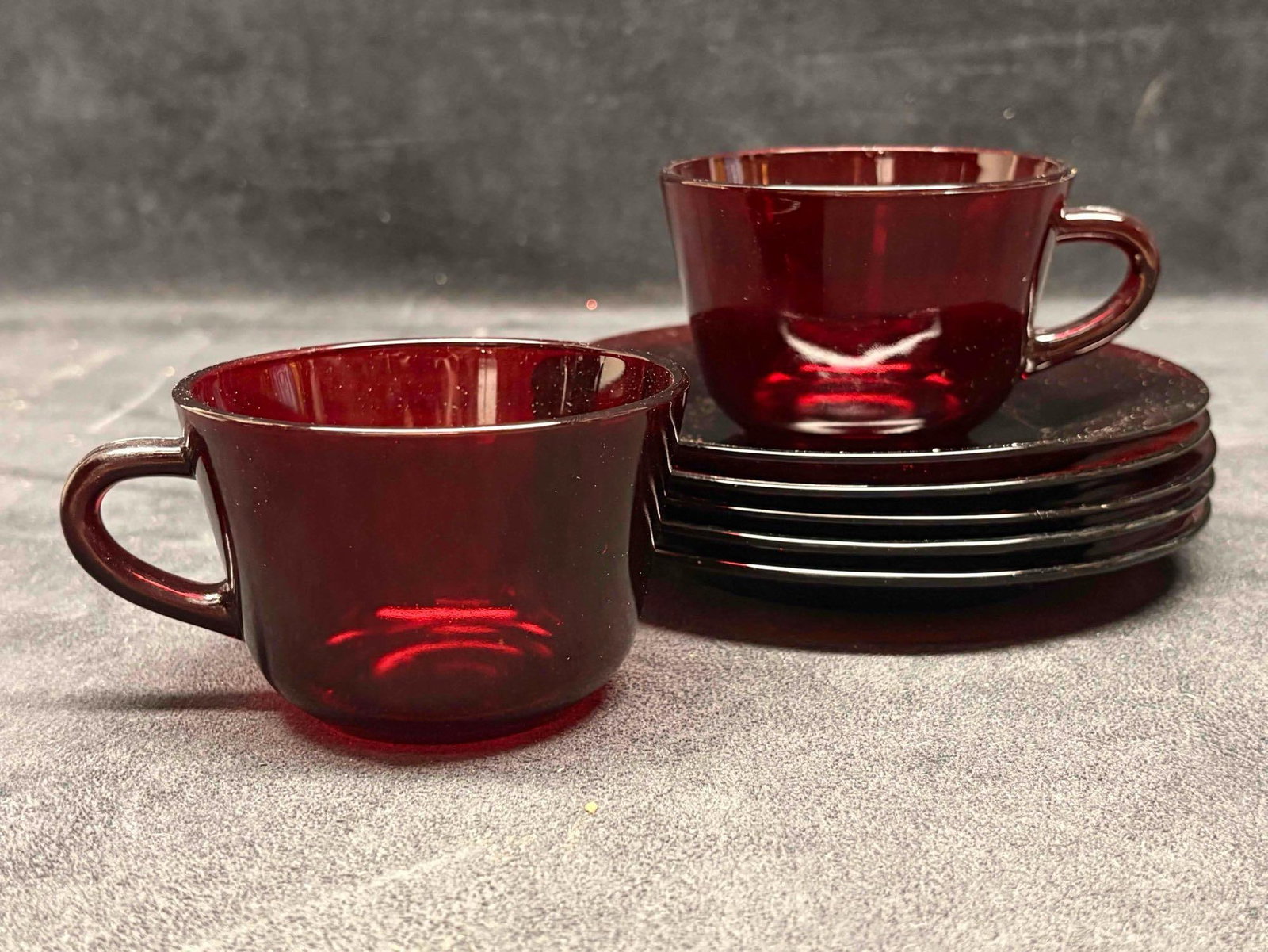 7pc Vintage Anchor Hocking Red Ruby Glass Teacup and Saucer Set: Produced by Anchor Hocking Glass Corporation, these mid-century pieces were manufactured starting in 1938 and remained popular through the 1960s-1970s. The set features a smooth, solid deep-red c