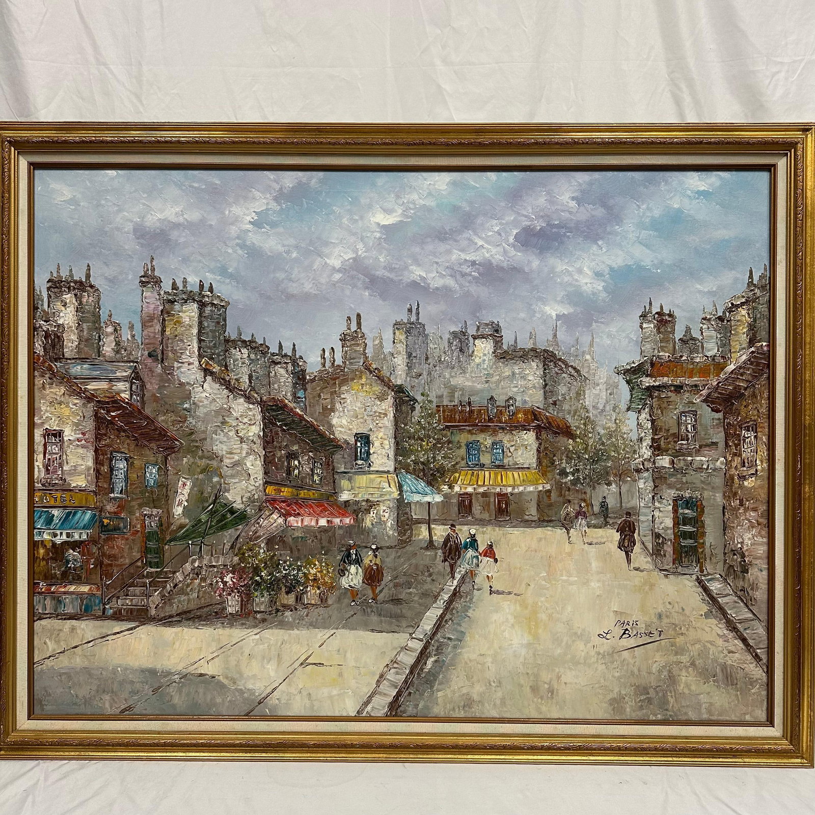 Large Original Oil Painting on Canvas framed Paris Street Scene Signed L. Basset: Large vintage oil-on-canvas painting depicting a Paris street scene with shops, still figures, and tall historic buildings. Signed L. Basset at the lower right-hand corner. The artwork features a