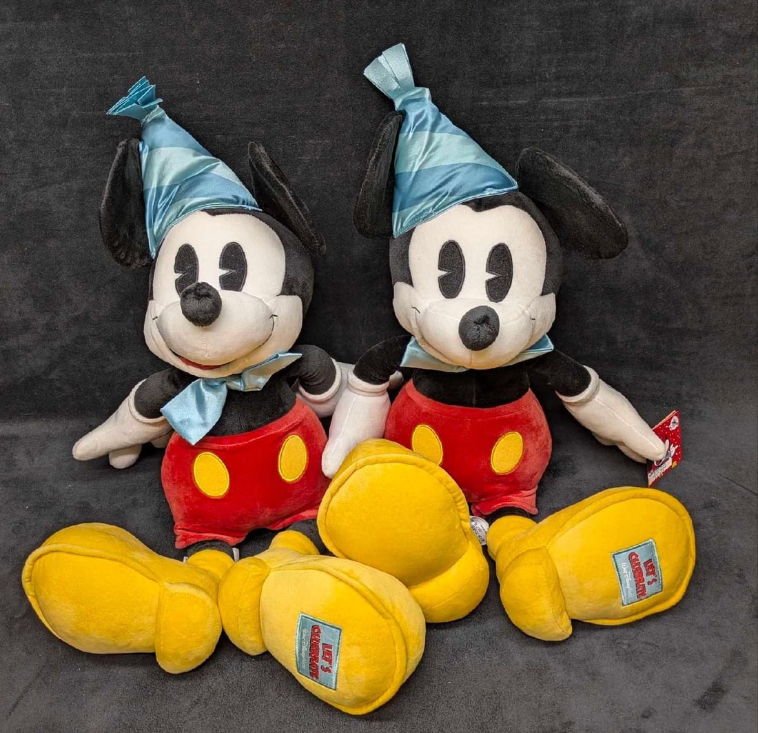 Two Large Walt Disney World "Let's Celebrate" Mickey Mouse Plushes: Two Large Walt Disney World "Let's Celebrate" Mickey Mouse Plushes. Each is approx 22" x 13 1/2" x 9" and the total weight is 2.10lbs. Both have light signs of wear. 