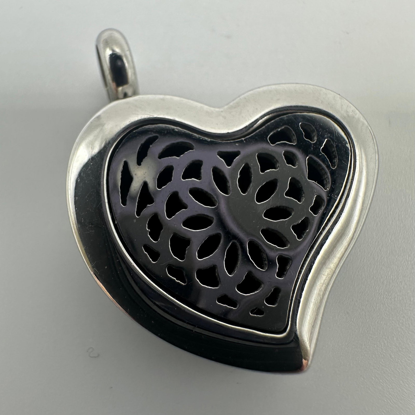 Aromatherapy Stainless Steel Open Silver Tone Heart Pendant: Necklace pendant that serves as a locket for diffusing essential oils. This item is in pre-owned, previously displayed condition with wear and surface markings. Please reference all photos for fu
