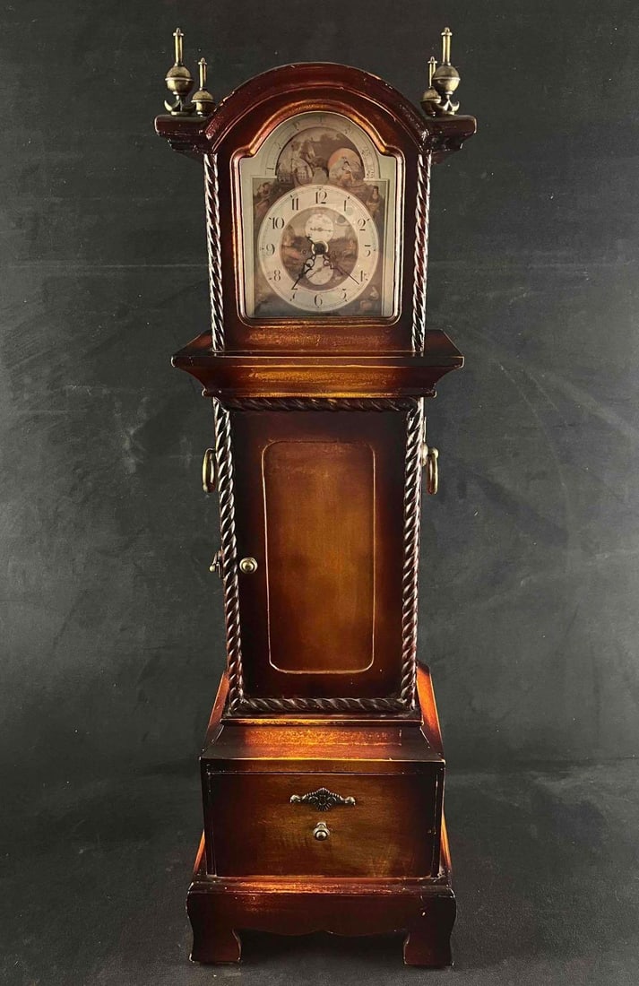 Wooden Clock With Storage: Wooden Clock With Storage This clock is wood and the finish on it is dark stained wood with light antiqued age spots. It has a braided edging around the door in the middle with a antiqued gold