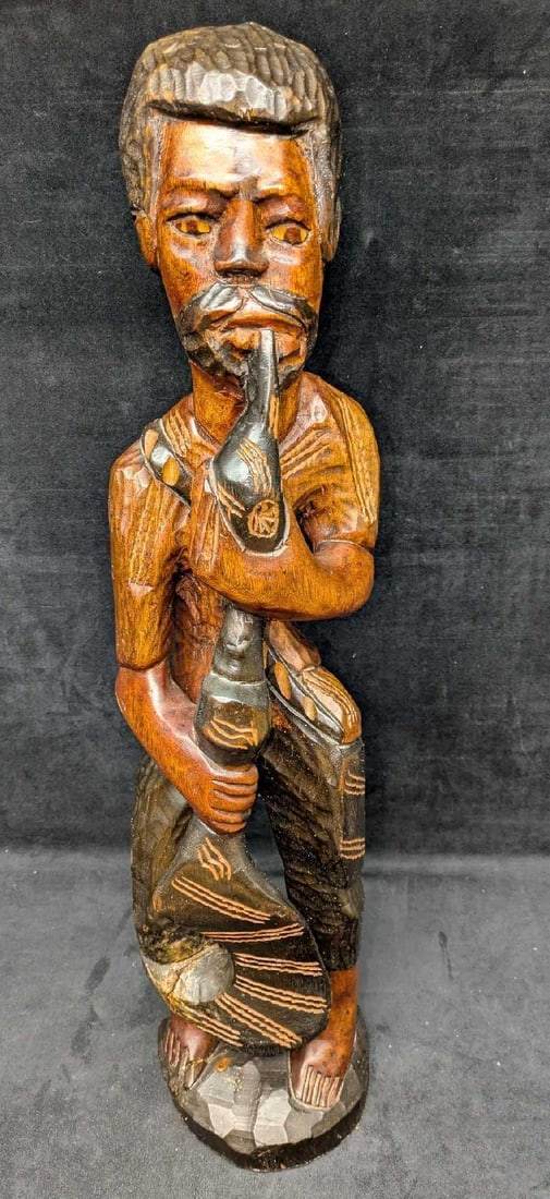 African Style Carved Wood Fisherman With Fishhook And Pipe Sculpture: African Style Carved Wood Fisherman With Fishhook And Pipe Sculpture. The man is either holding an giant fishhook or an odd shaped paddle. This is approx 6" x 5" x 25 1/2" and it weighs 5.50lbs. The s