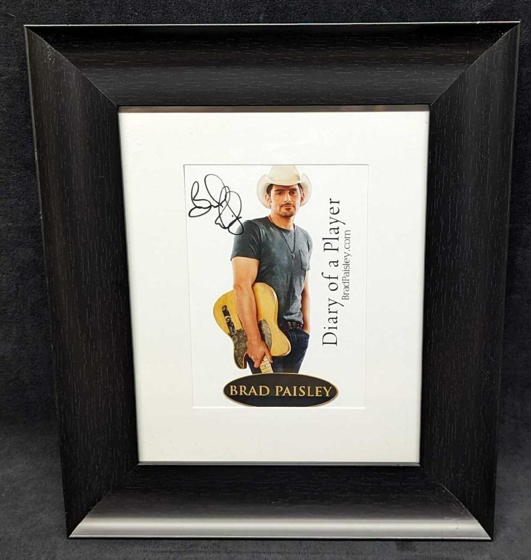 Framed Autographed Brad Paisley Book Print: Framed Autographed Brad Paisley Book Print. This shows the cover of the autobiography of the American country music singer. This framed print is approximately 11 3/8" x 1" x 13 1/2" and it weighs