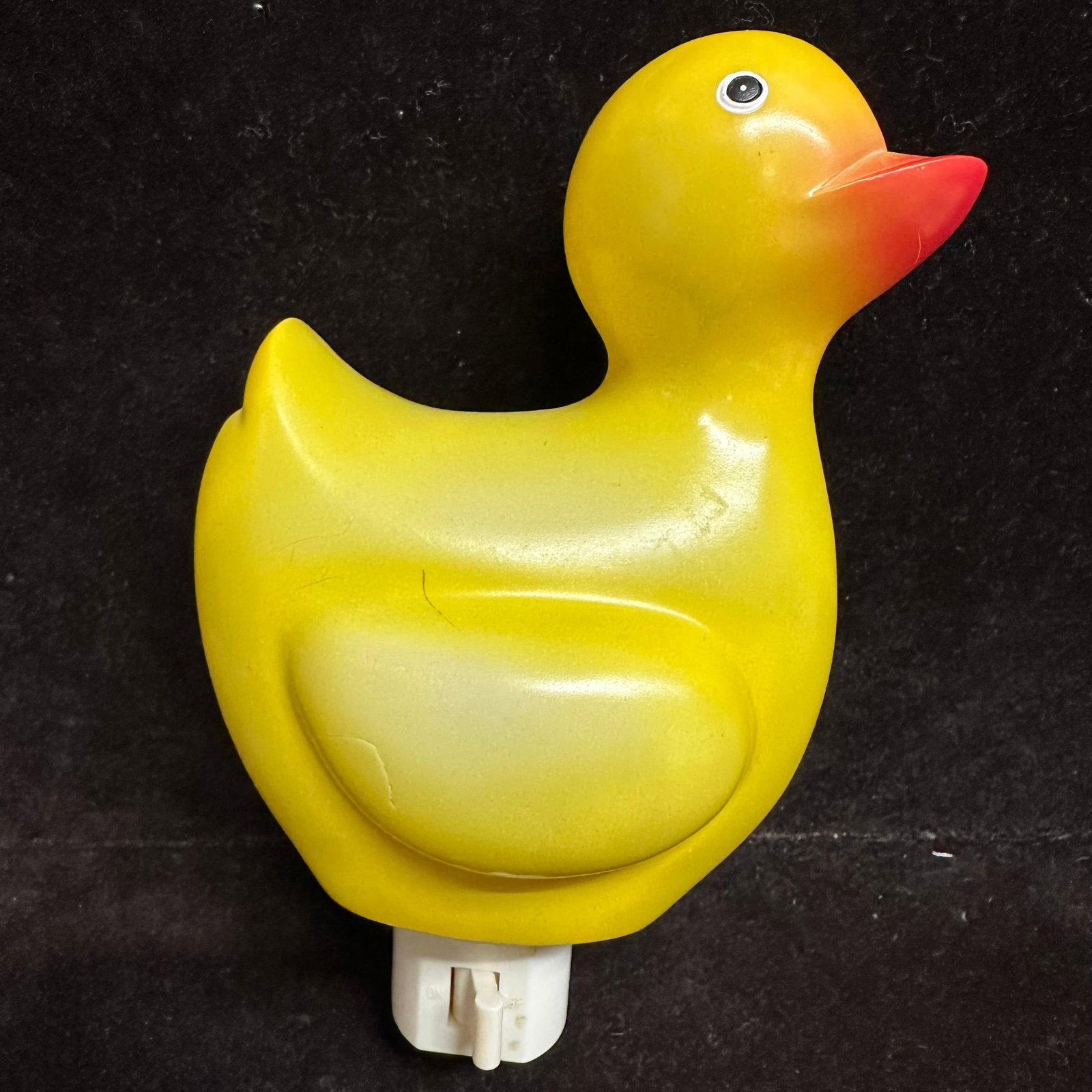 Vintage Duck Night Light Plug In Lamp Yellow Hard Plastic Nursery Decor: Vintage plug-in duck night light featuring a yellow molded hard plastic body with an orange beak. Uses a small candelabra-style bulb (included). On/off switch located on the plug base. Emits a soft am