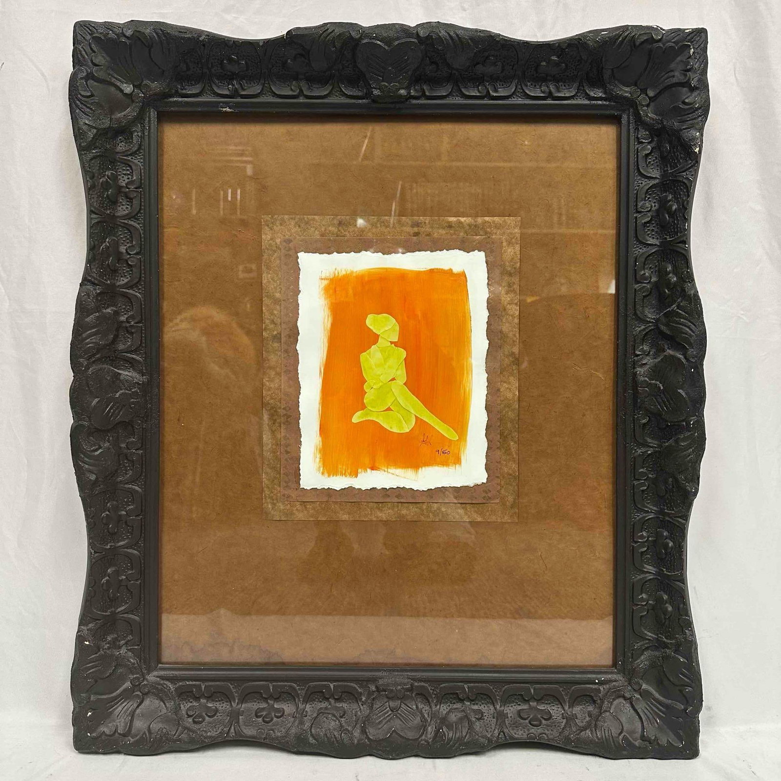 Black Frame Mixed Media Sunlit Repose Minimalist Silhouette Seated Figure Numbered R148: This framed artwork features a minimalist silhouette of a seated figure, rendered in vibrant yellow against a bold orange background. The piece is presented on textured paper with a torn edge, adding 
