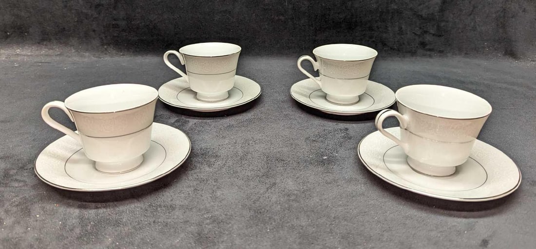 4 Retired International Juliet Saucers & Tea Cups C: 4 Retired International Juliet Saucers & Tea Cups C. This lot of fine china contains: (4) Saucers. Each is approx 6" x 6" x 3/4". The design has some discoloration. (4) Tea Cups. Each 