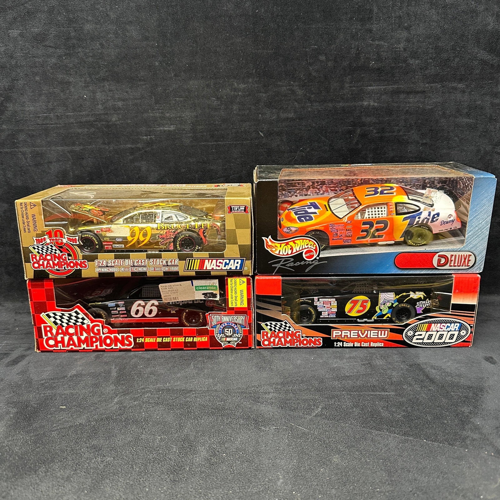 Group of 1:24 Scale NASCAR Die Cast Stock Car Replicas Lot of 4: Group of four 1:24 scale NASCAR die-cast stock car replicas, including Racing Champions and Hot Wheels examples. Lot includes #99 Bruce Lee commemorative car, #32 Tide Hot Wheels Racing Deluxe car, #6