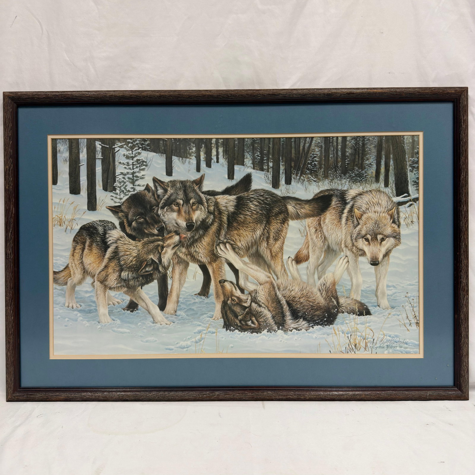 Cynthie Fisher Signed and Numbered Wolf Print Dated 92: Limited edition wildlife print by Cynthie Fisher, depicting a pack of wolves interacting in a snowy forest landscape. Hand-signed by Cynthie Fisher at lower right, dated 1992, and numbered 247/250. Ov