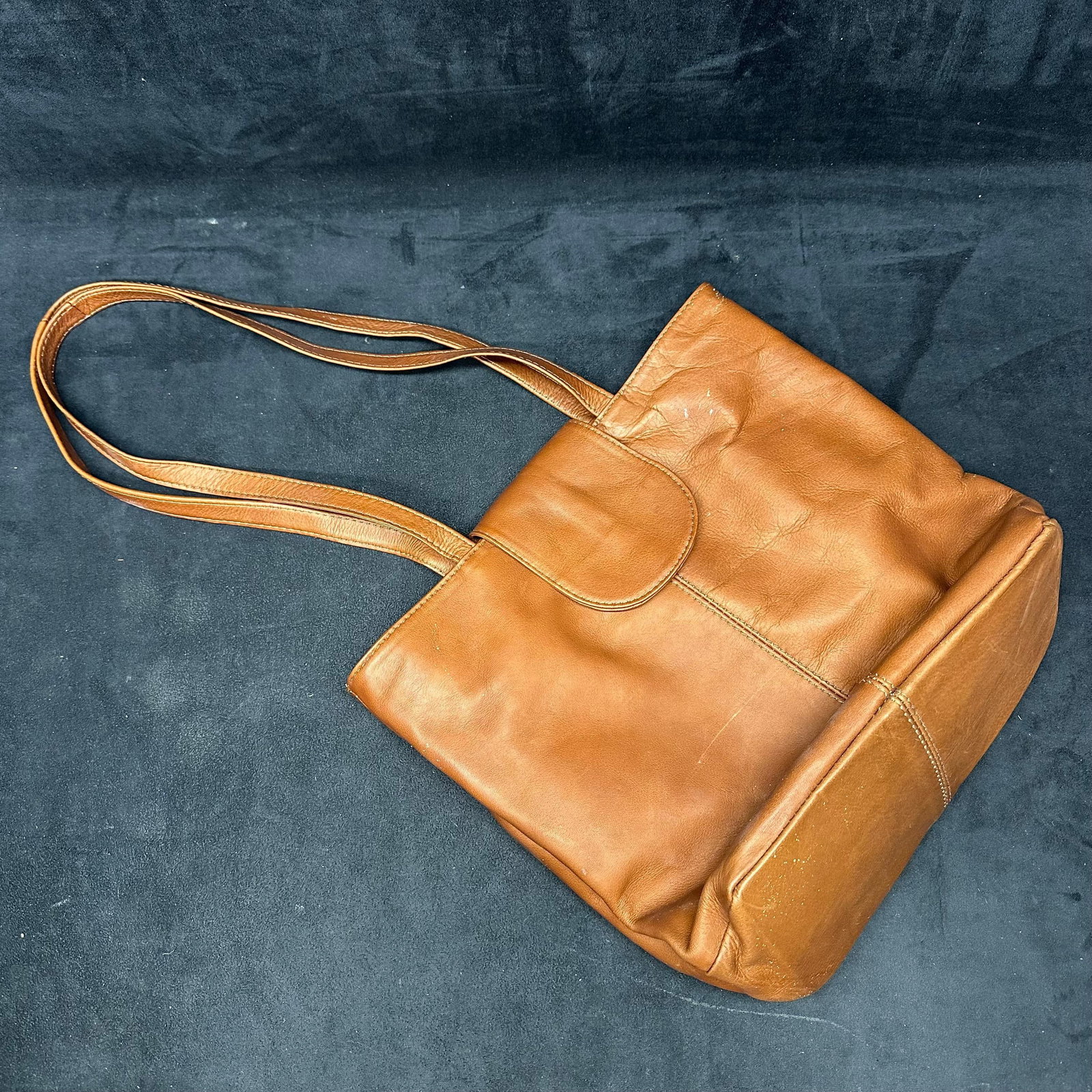 HOBO International Brown Leather Tote Bag: HOBO International leather tote in brown with double shoulder straps and magnetic snap closure. Features a soft, slouchy leather body, interior zip pocket, and fabric lining. Shows visible wear and sc