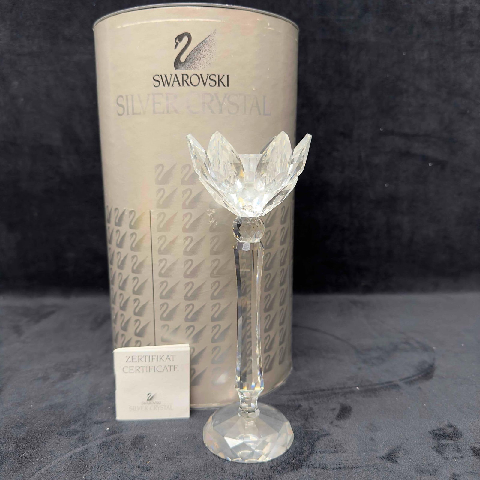 Swarovski Crystal Tulip Candle Holder Water Lily 7600 NR 141 000 Broken Repaired A: Swarovski Clear Crystal Glass Tulip Water Lily Candle Holder. This Candle Holder is a beautiful crystal glass art piece featuring a Tulip from Swarovski Crystal. The item features a beautifully etched