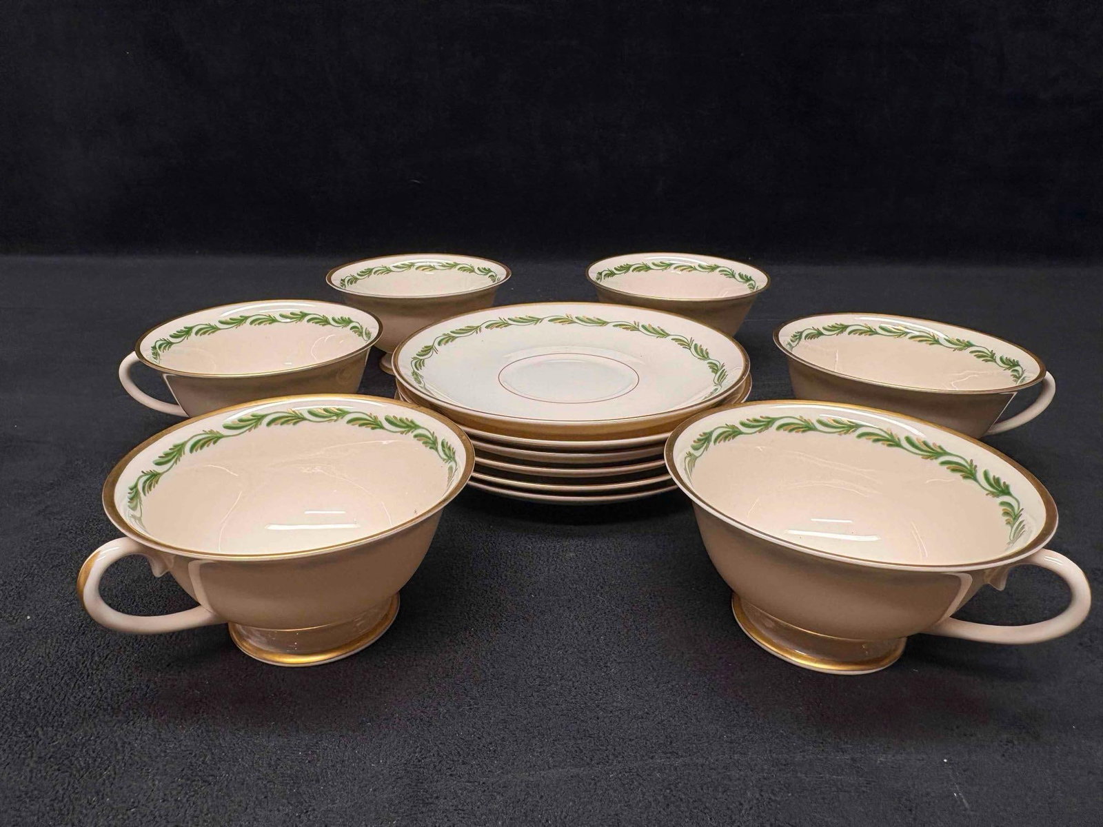 12pc Vintage Franciscan Arcadia Green Plumes Footed Teacup and Saucers: Adorned with green plumes and gold accents, this china tea set is a part of the now discontinued Arcadia Green line by Franciscan. Producing during the early 1940s to early 1960s, this lot is in good 