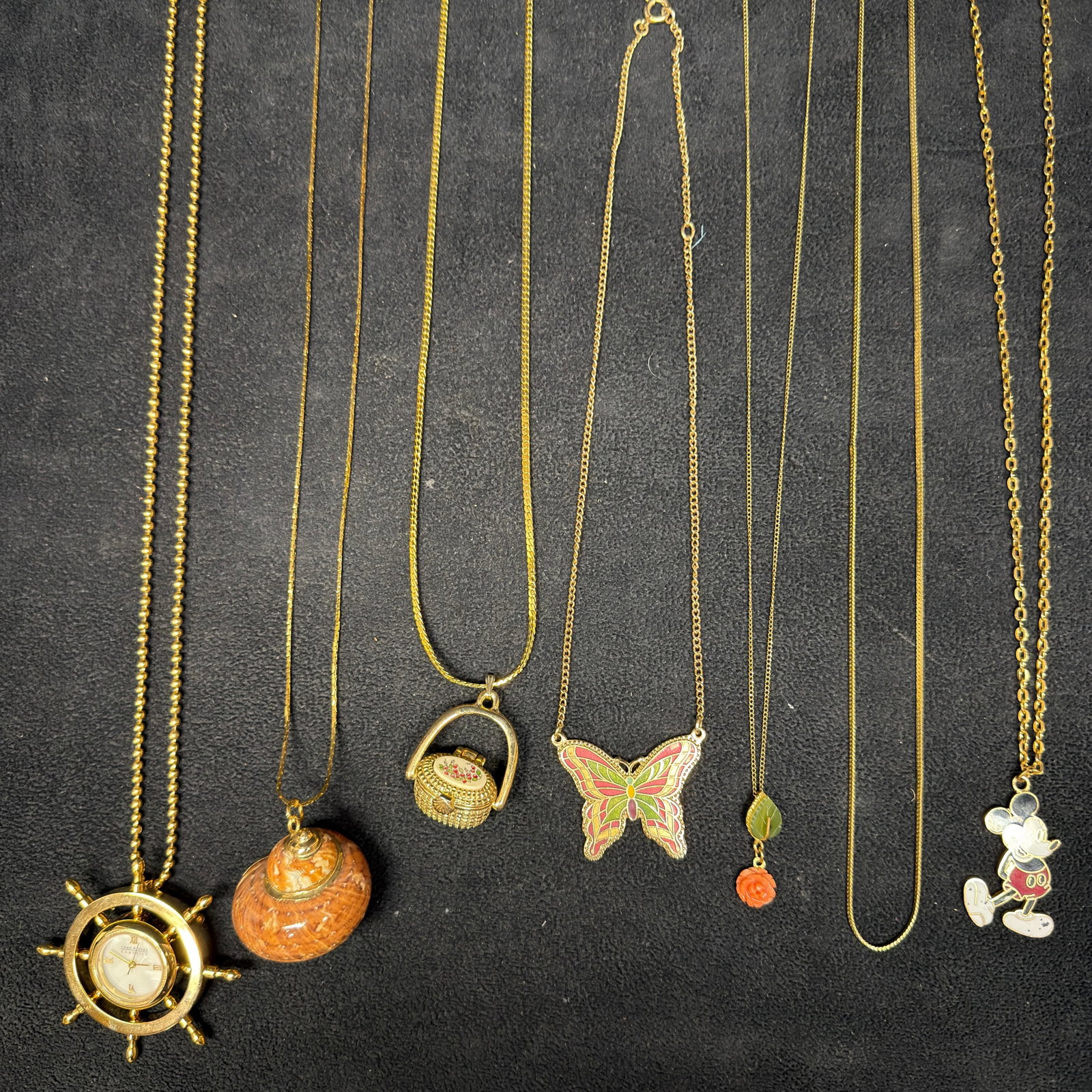 Gold Tone and Gold-Filled Necklace Collection Joan Rivers Sara Coventry: Collection of seven gold-tone and gold-filled necklaces featuring Disney, Joan Rivers, Sarah Coventry, and more. These items are in pre-owned, previously used condition with light wear and surface scr