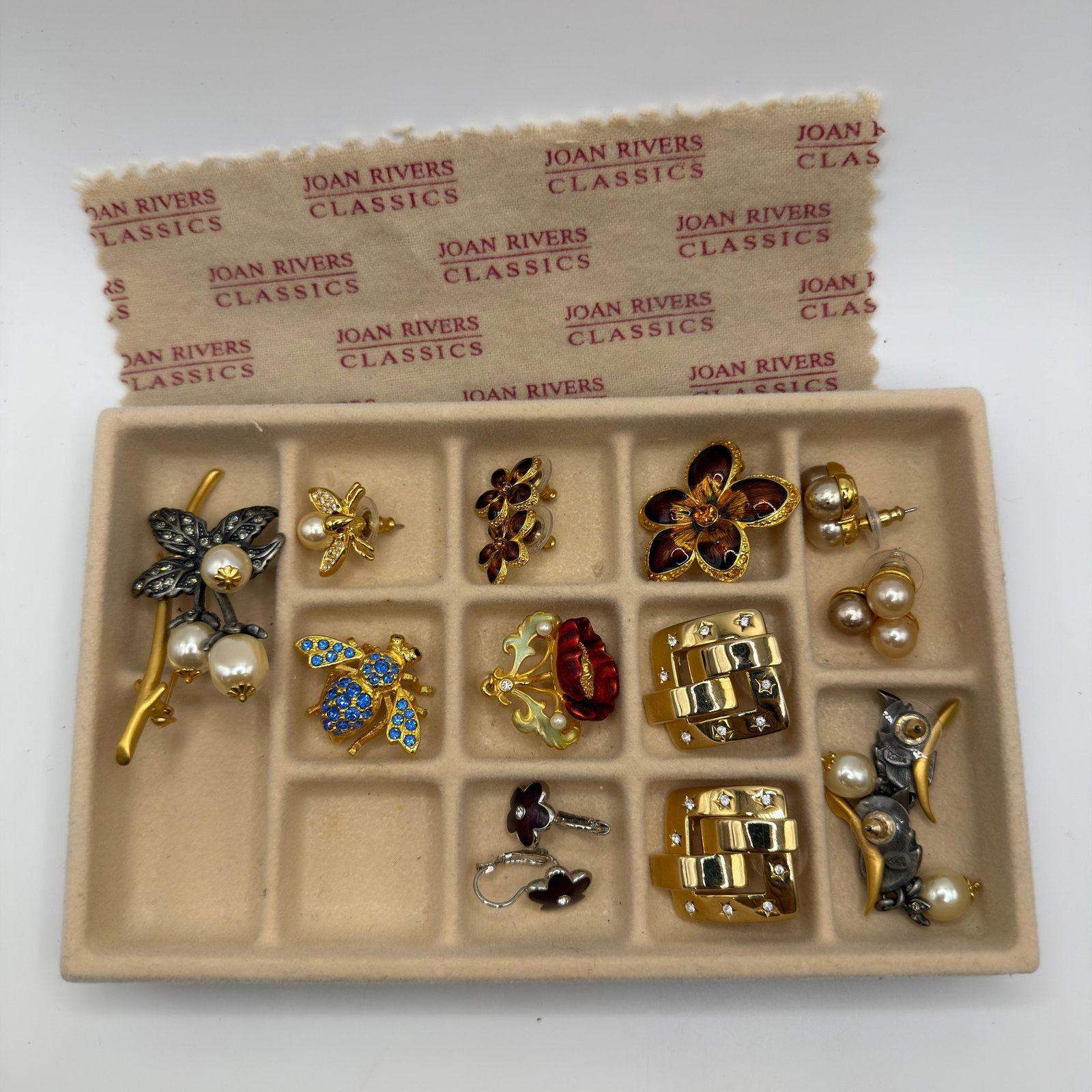 Collection of Joan Rivers Costume Jewelry Brooches and Earrings Floral Bee Style: Collection of Joan Rivers costume jewelry including floral brooches, simulated pearl botanical brooches, blue rhinestone bee brooch, enamel flower brooch, floral earrings, simulated pearl earrings, ge