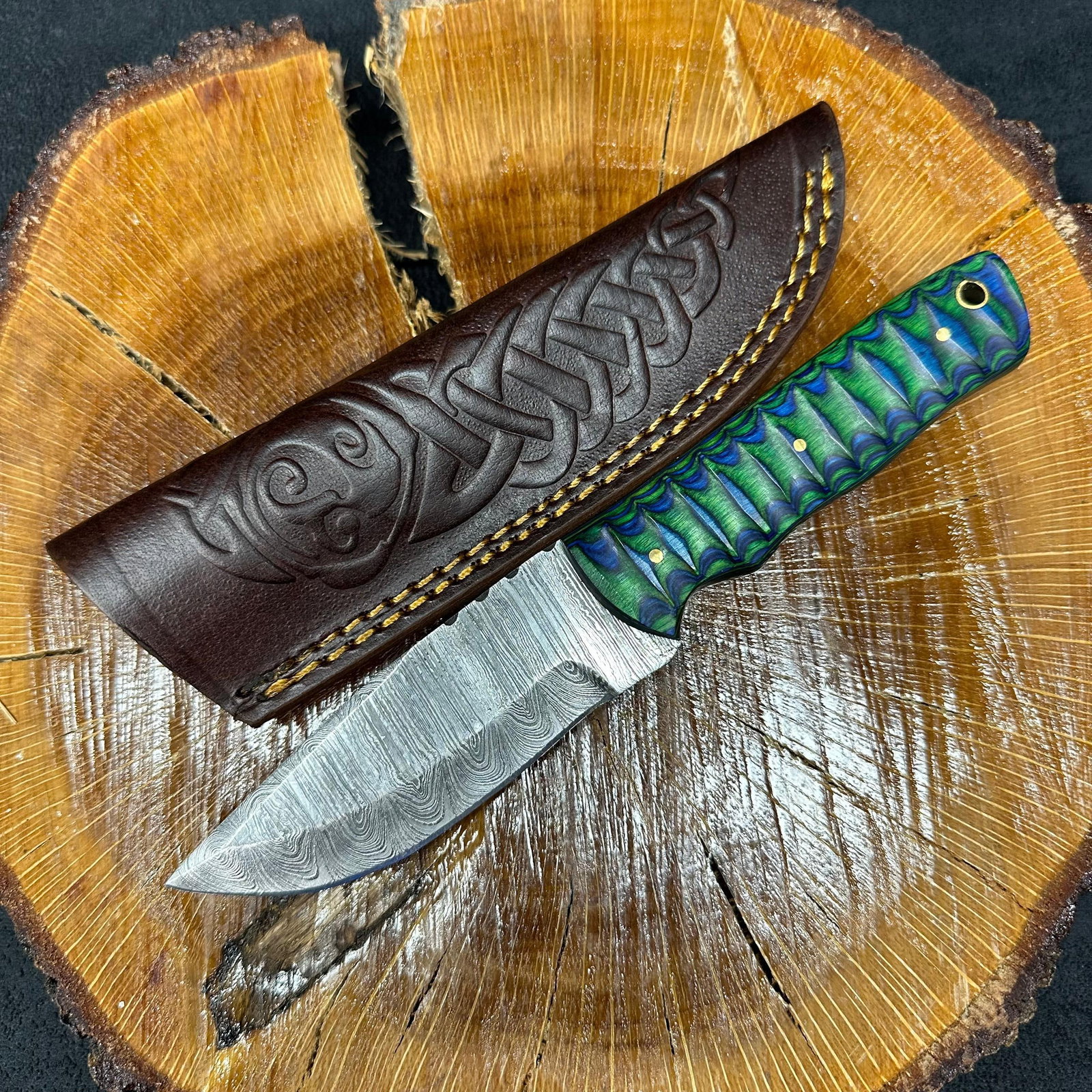 Green Blue Handle MHS Cutlery Fixed Blade Knife Q18: Fixed blade knife by MHS Cutlery featuring a layered patterned steel blade and decorative spine work. The handle has a contoured, multi-colored wood/epoxy resin-style grip with metal mosaic pin accent