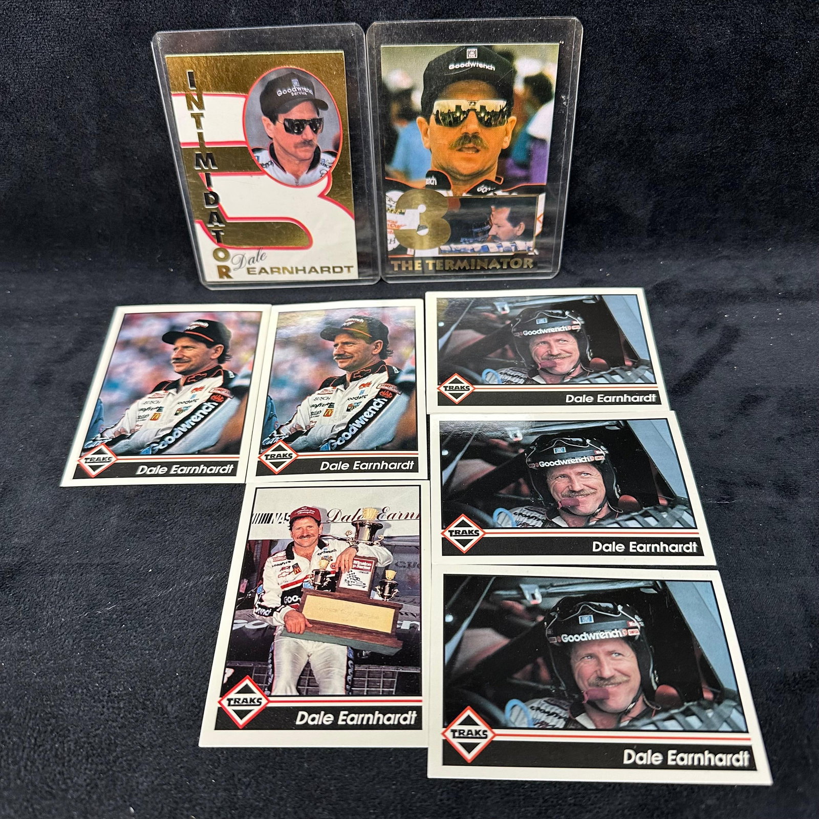 Dale Earnhardt Traks Card Collection Two Foil Cards: Included in this Dale Earnhardt NASCAR lot are six 1900s Traks cards and two foil cards. Loose cards and two cards are presented in rigid plastic sleeve protectors. These items are in good pre-owned, 