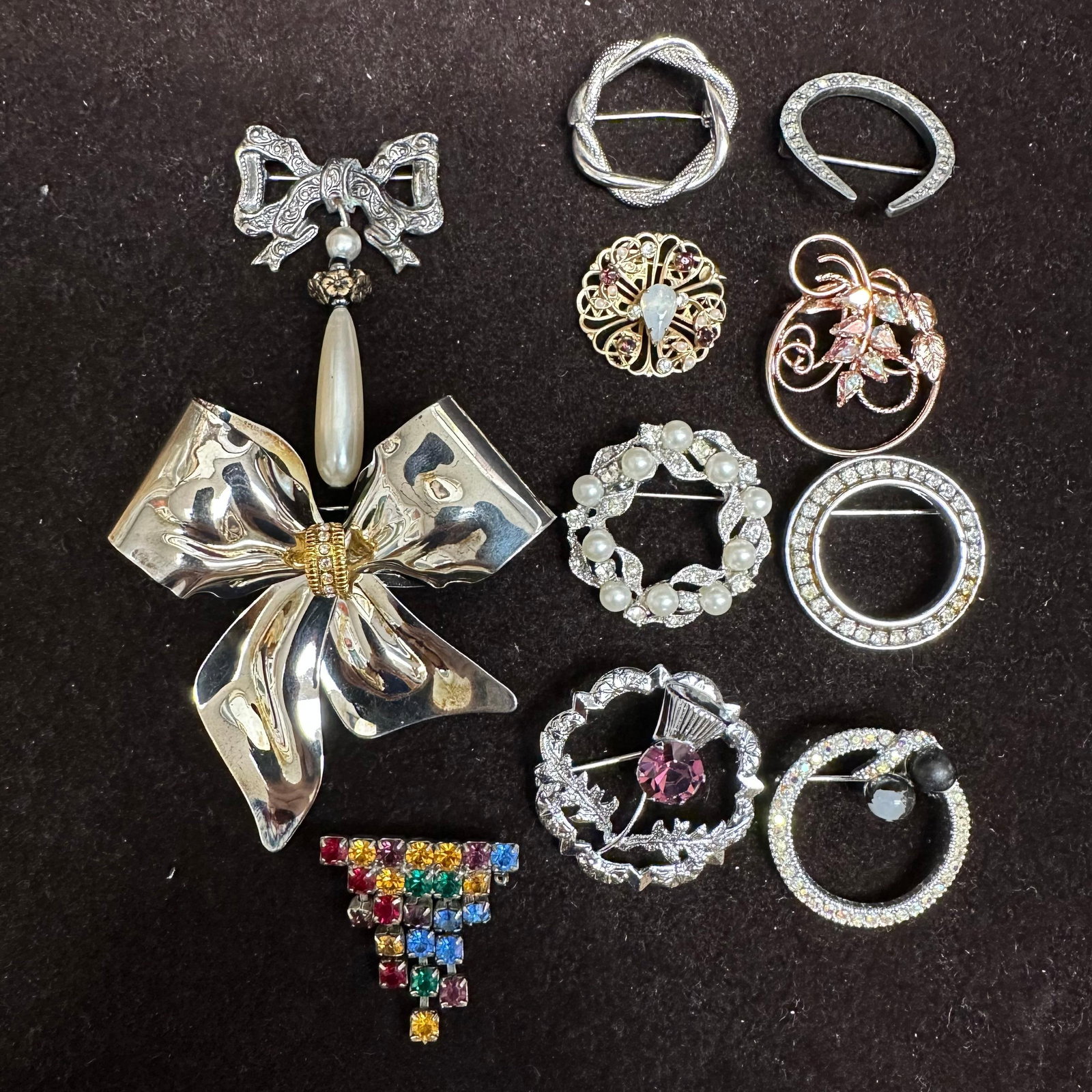 Vintage Rhinestone And Bow Brooch Pin Lot Circle Floral Faux Pearl Costume Jewelry Q39: Group of vintage costume jewelry brooches, including rhinestone circle pins, floral designs, faux pearl accents, and a large bow brooch. Features gold and silver-tone metal with clear and multicolor s