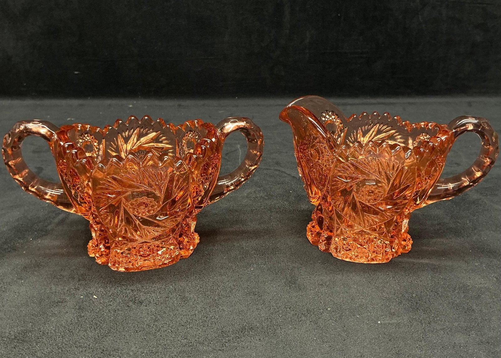 Imperial Glass Co Marigold Pinwheel and Starburst Crystal Cut Pattern Sugar Bowl and Pitcher: This lot contains two (2) pink/rose gold (often referred to as Marigold) pieces from the Imperial Glass Company. Both are heavy glass dishes with the manufacturer's commonly identifiable Pinwheel 