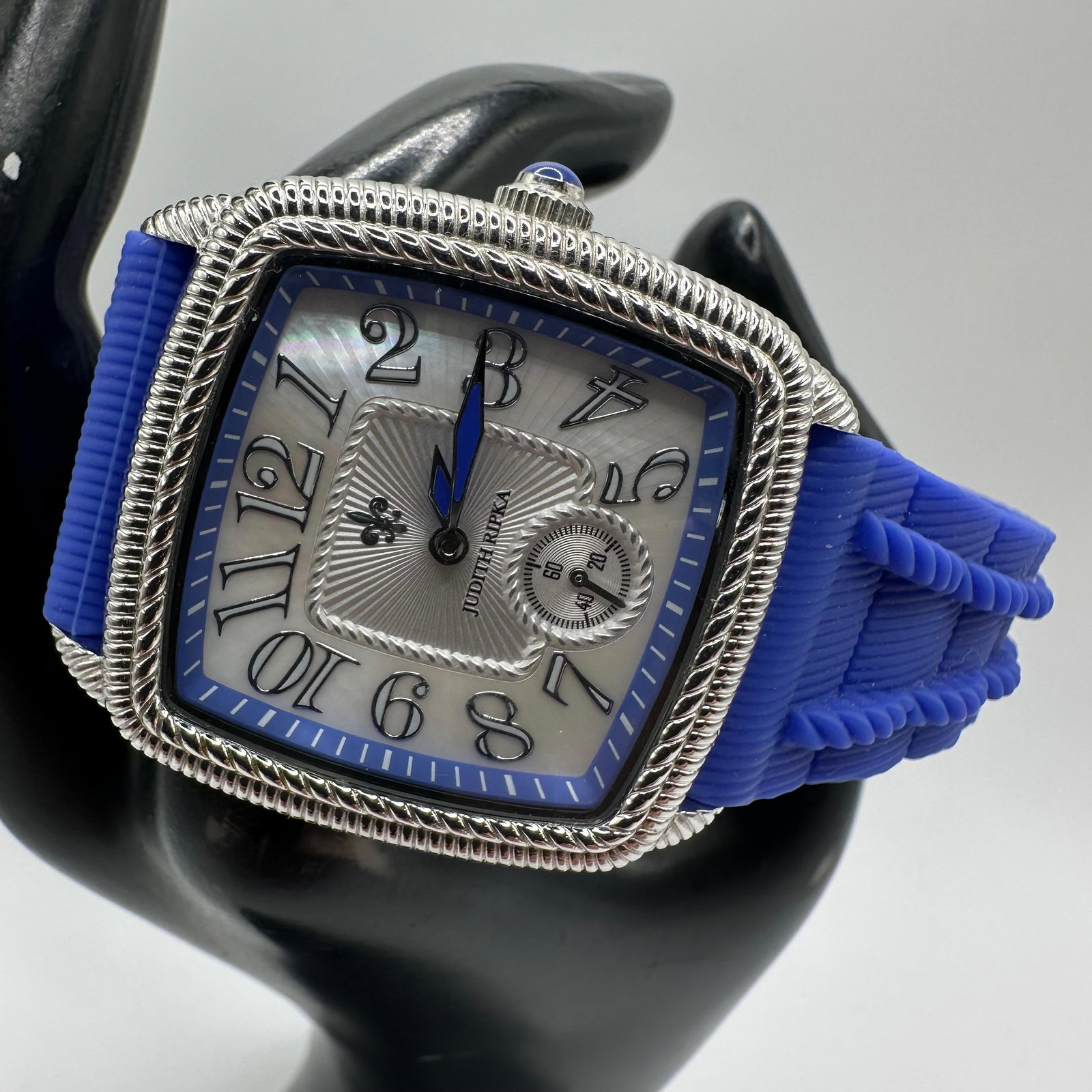 Judith Ripka Stainless Steel Watch Blue Strap Mother Of Pearl Dial Japan Movement: Judith Ripka wristwatch with a stainless steel case and a blue silicone strap. Features a mother-of-pearl dial with stylized Arabic numerals and a sub-seconds display. Japan movement. Marked Judith